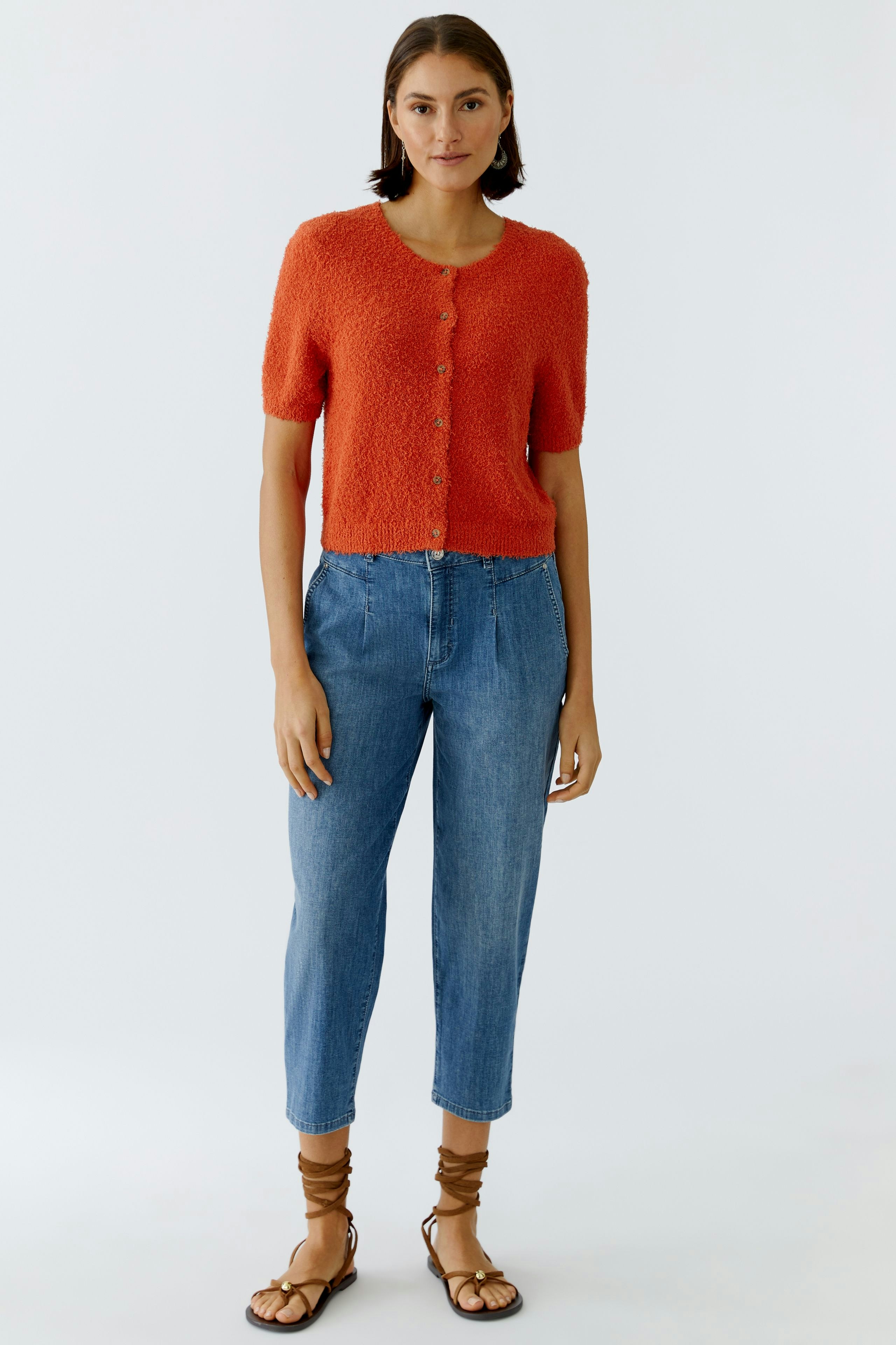 Casual women's jeans barrel: A woman in light blue barrel jeans paired with a textured orange pullover.