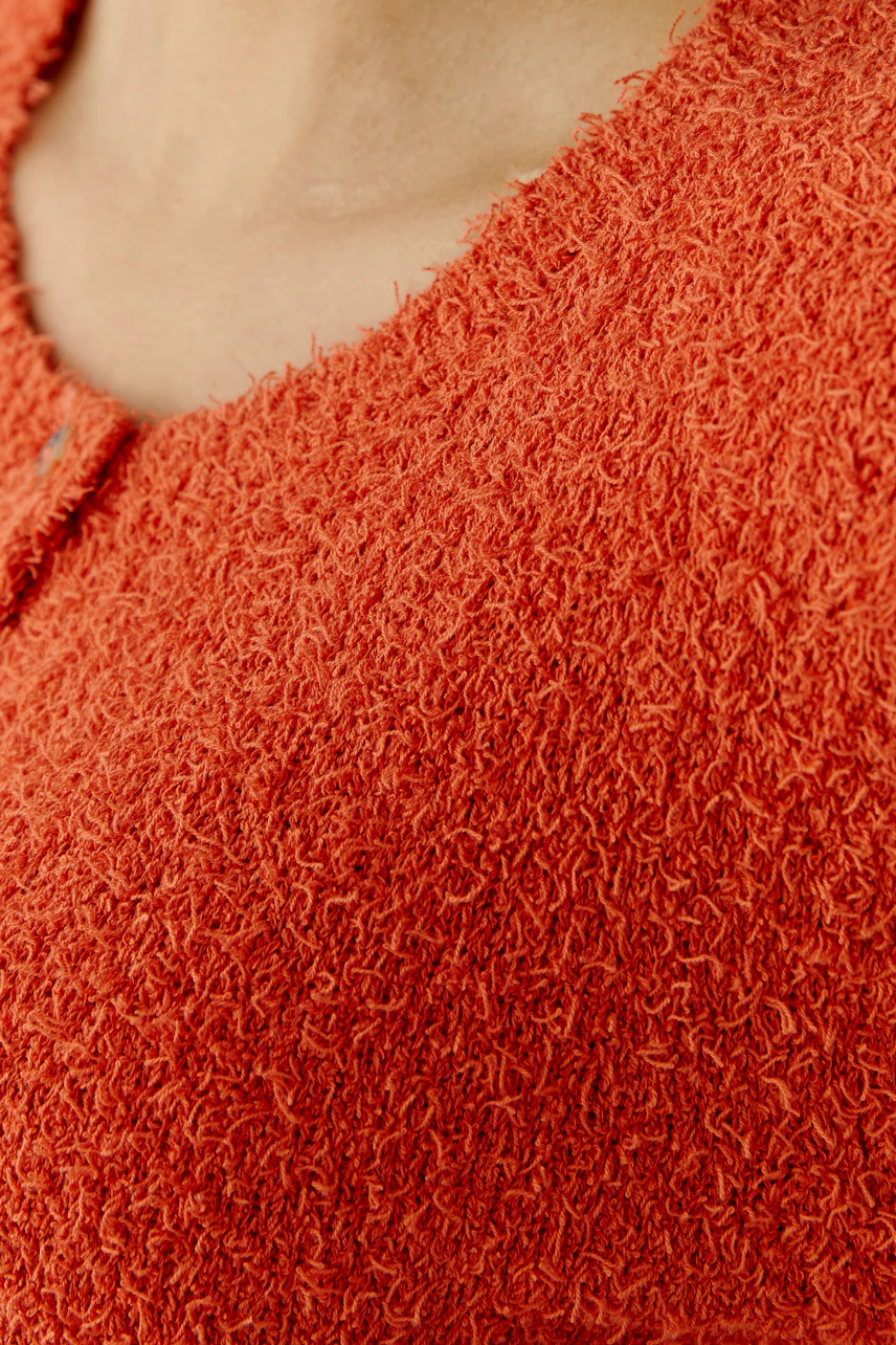 Cozy women's cardigan in vibrant orange with a textured finish, perfect for casual layering.