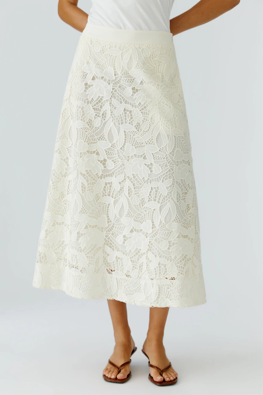 A-line skirt: Woman in a white lace skirt with a flowy design, perfect for casual summer outings.