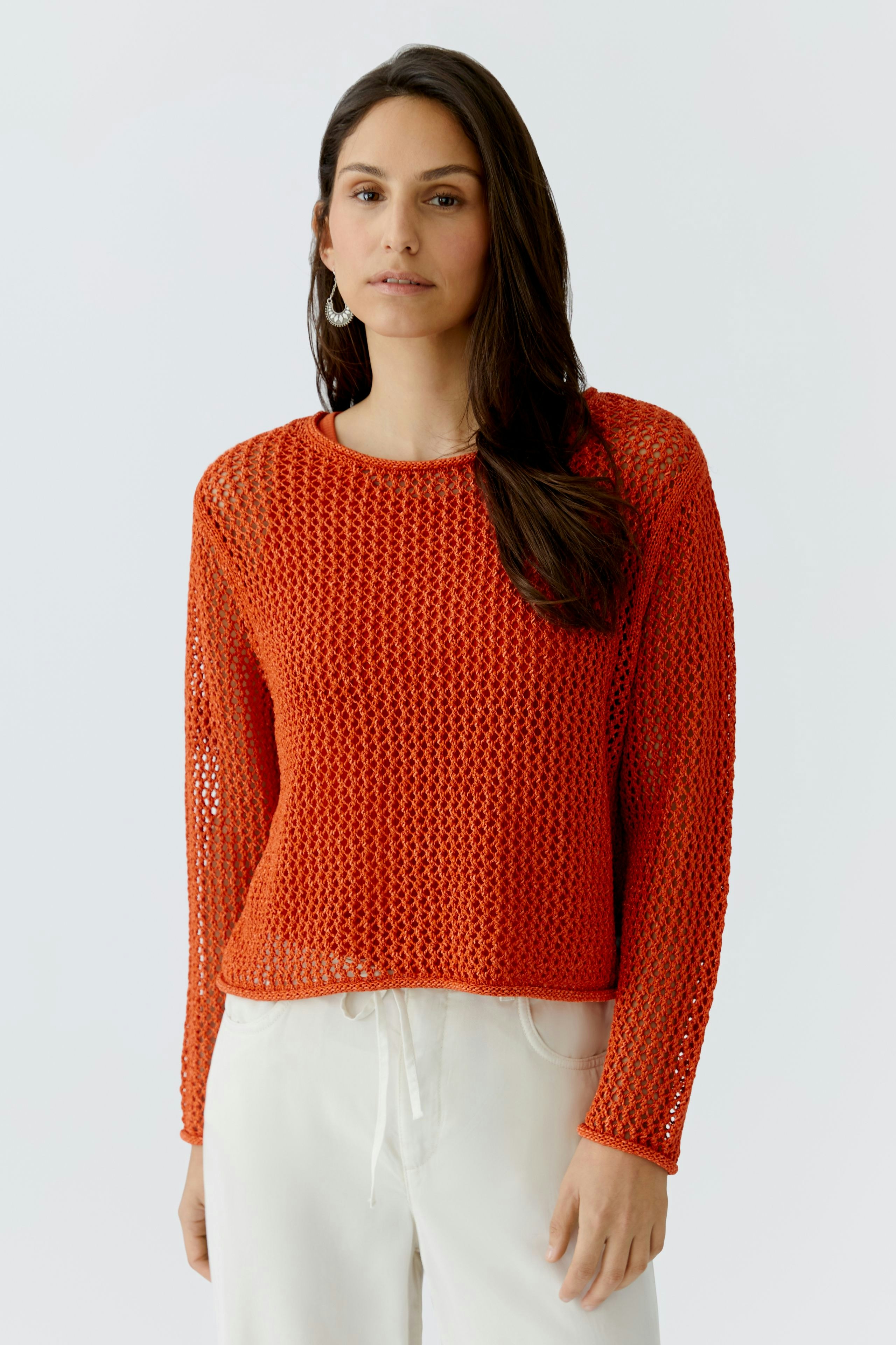 Damen-Pullover: Frau in rotem, luftigen Strickpullover mit weitem Schnitt und lässigem Look.