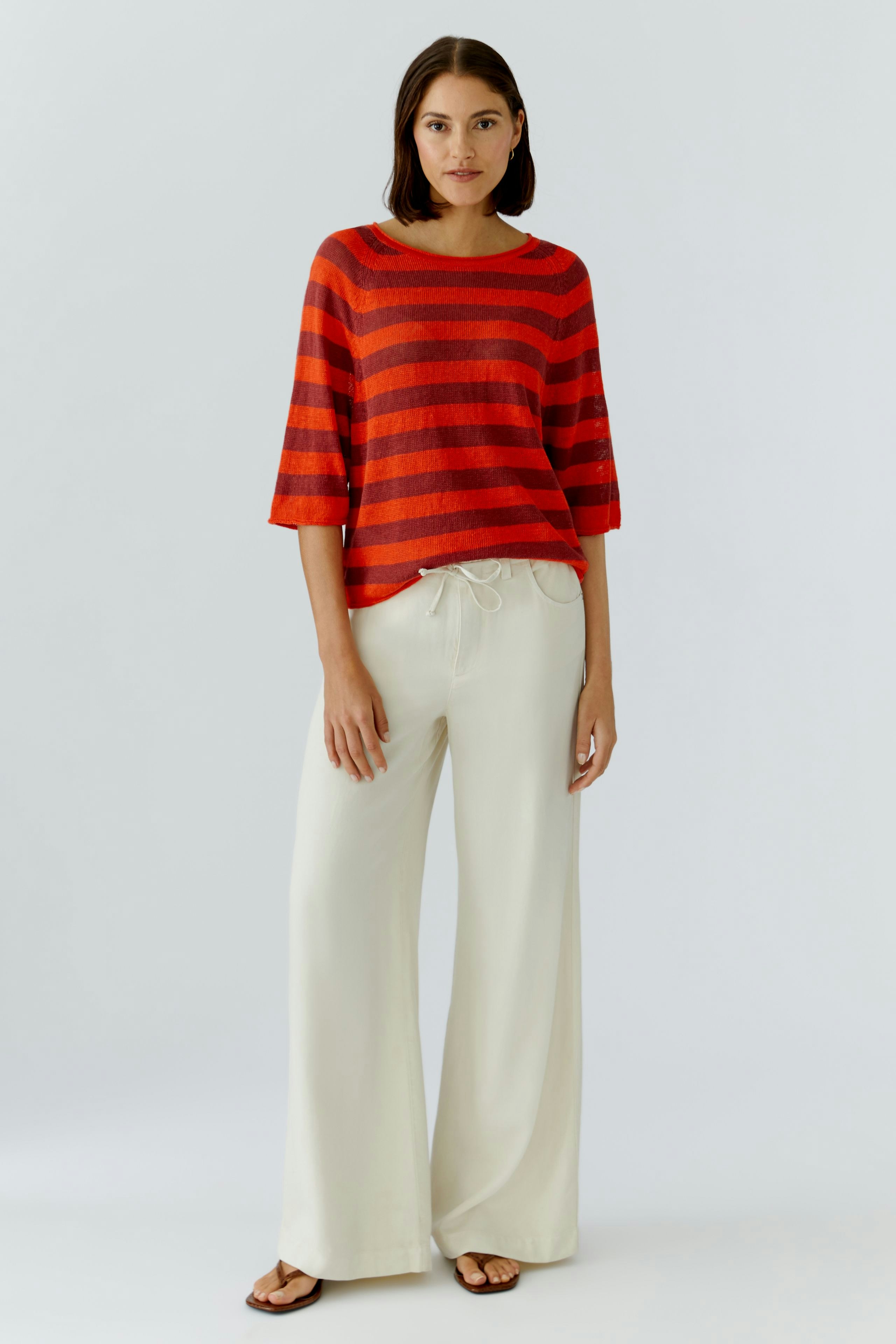 Damen-Pullover: Frau in rot-gestreiftem Pullover mit lässigen, weiten Hosen.