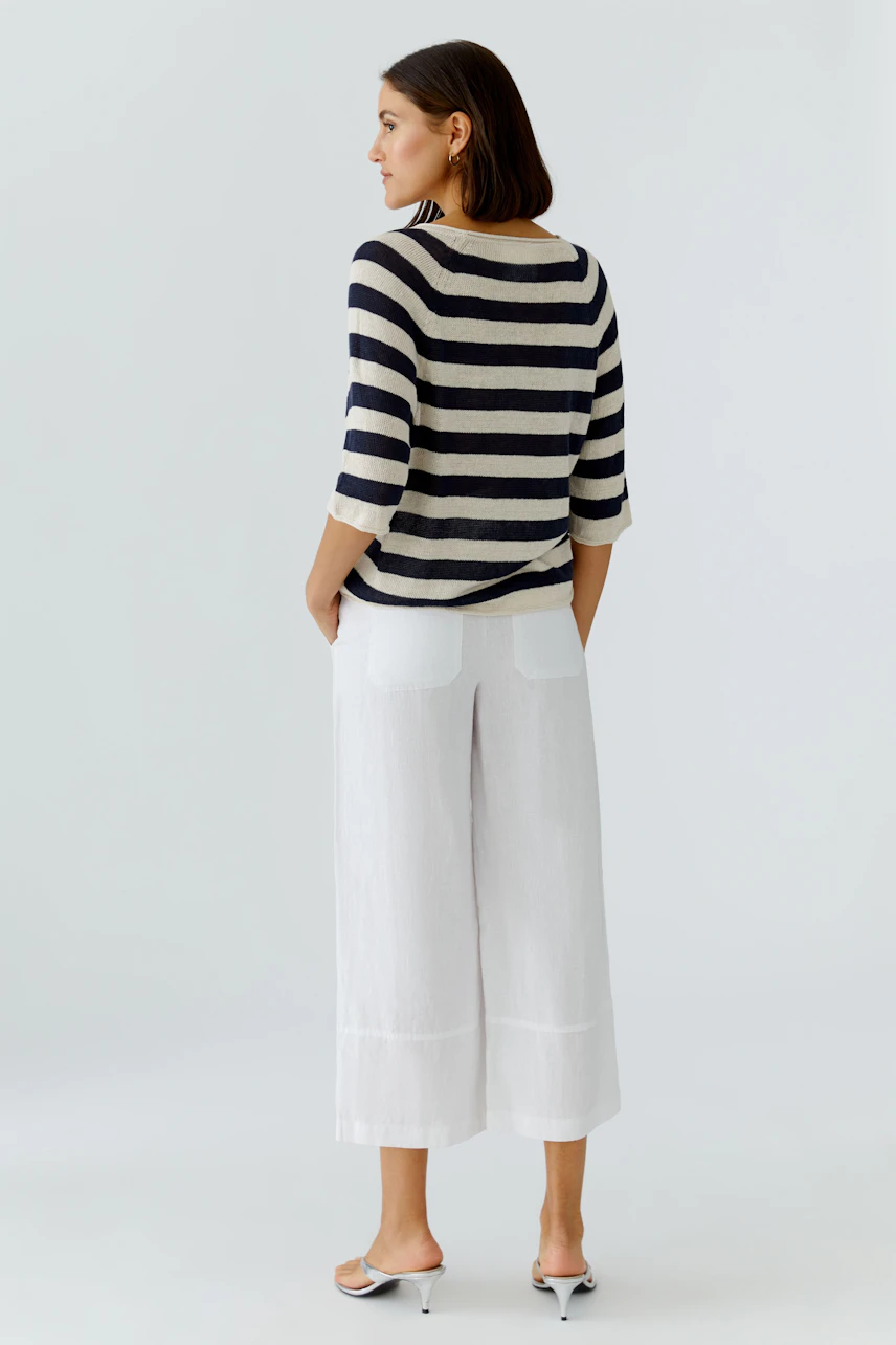 Casual women's pullover: A woman in a striped pullover with three-quarter sleeves and relaxed fit.