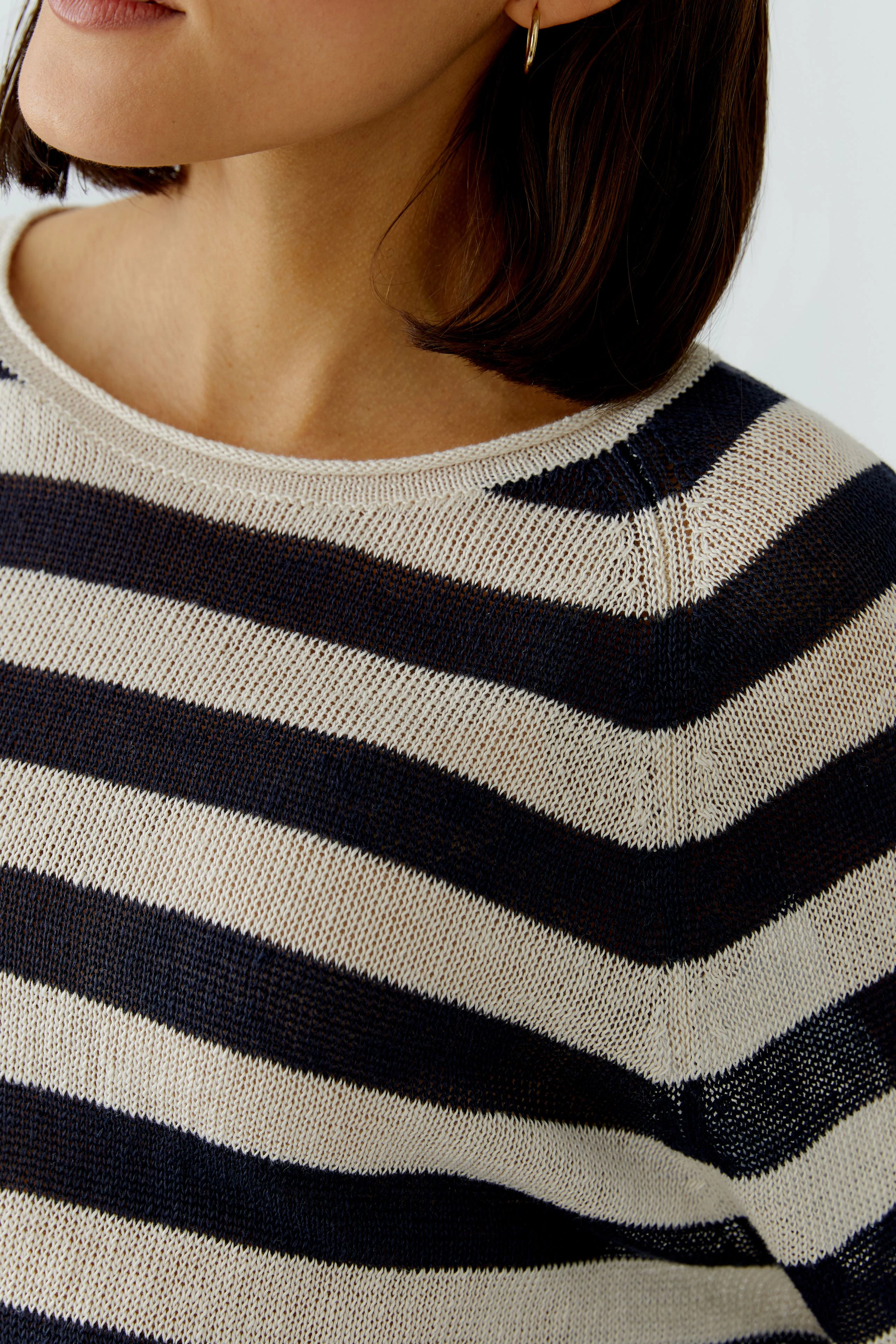 Damen-Pullover: Frau mit gestreiftem Pullover in Blau und Beige, lässiger Look.