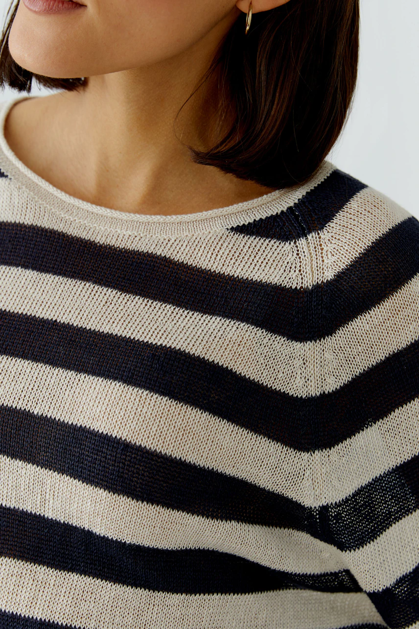 Casual women's pullover: Close-up of a woman in a striped pullover with navy and cream colors.