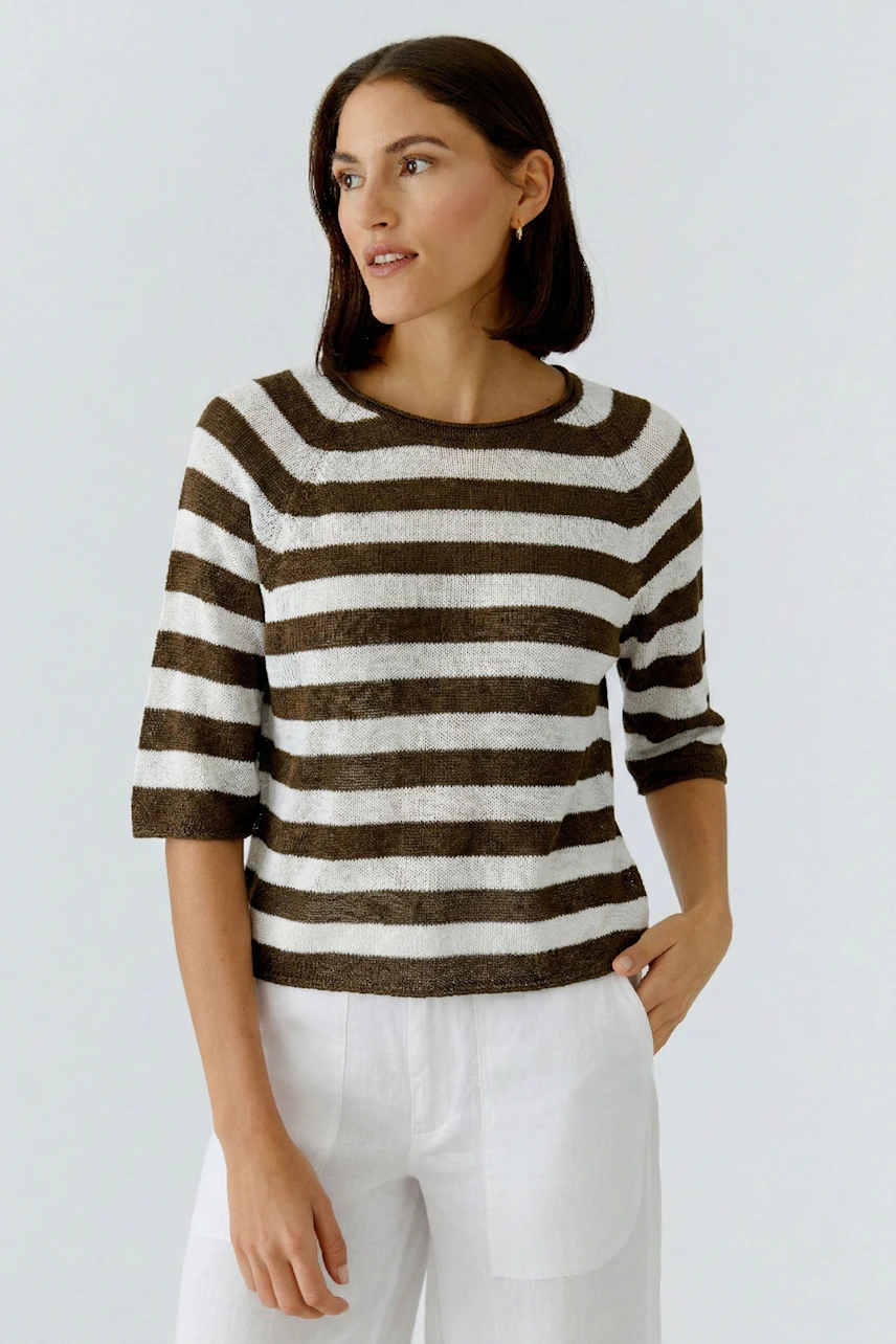 Casual women's pullover: Young woman in a striped pullover with three-quarter sleeves, paired with light trousers.