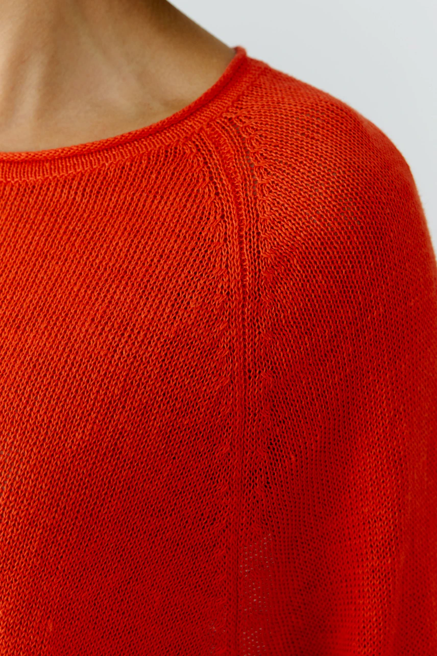 Casual women's pullover: Close-up of a vibrant red knit pullover with a relaxed fit and wide neckline.