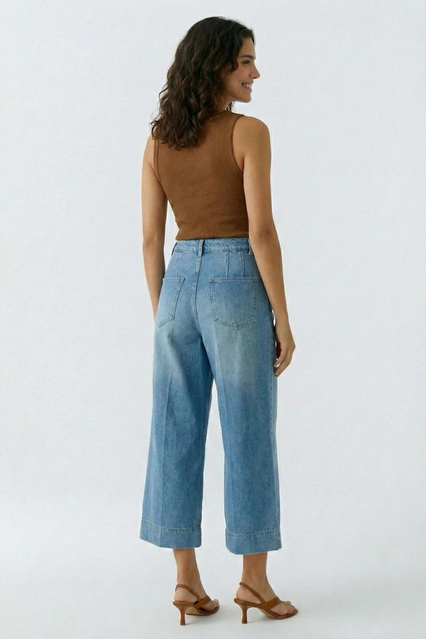 Damen-Tank Top: Frau mit braunem Tank Top und hellblauen Jeans von hinten.