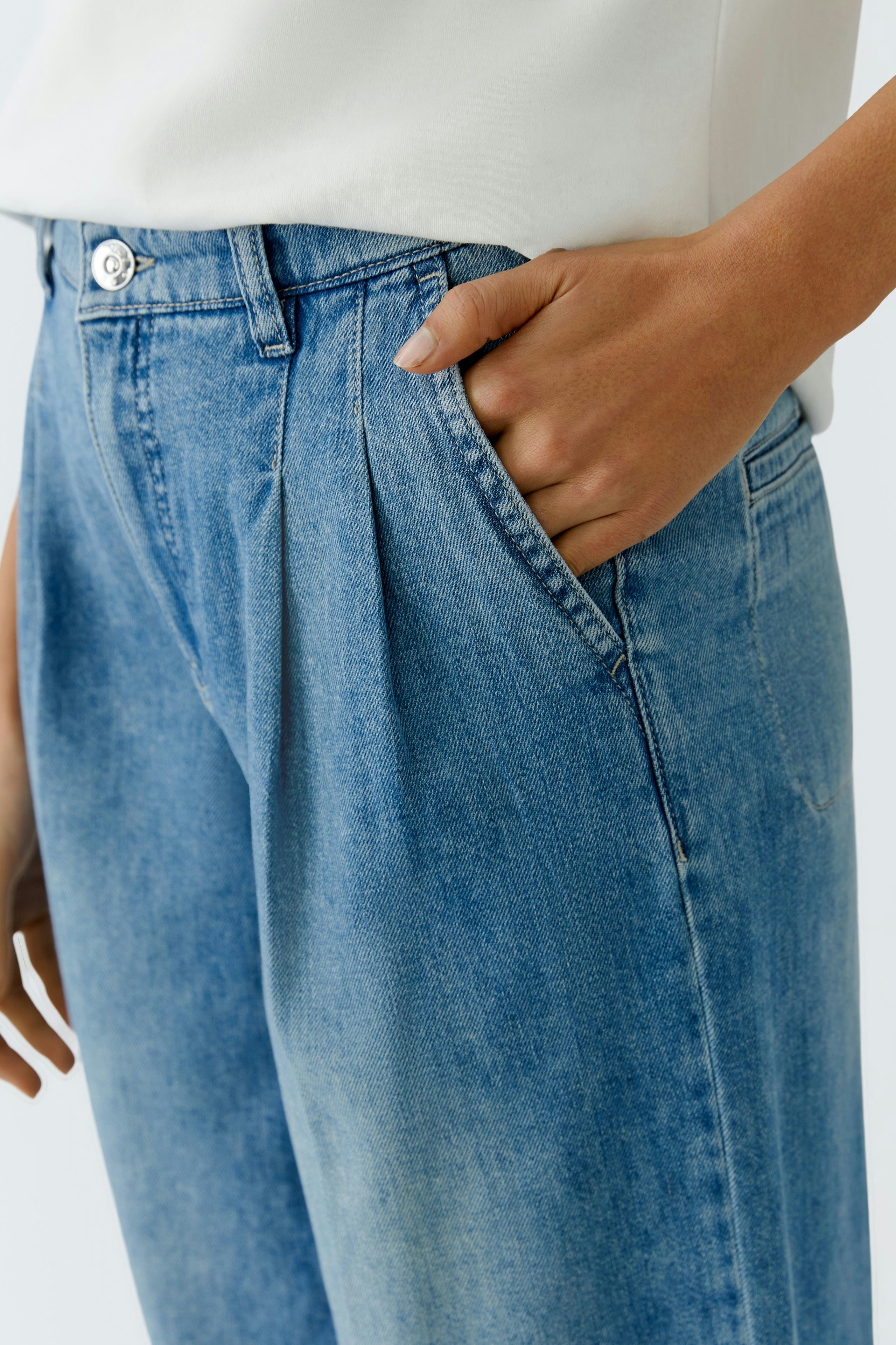 Bundfaltenhose: Damenhose in hellem Denim mit Bundfalten und seitlichen Taschen.
