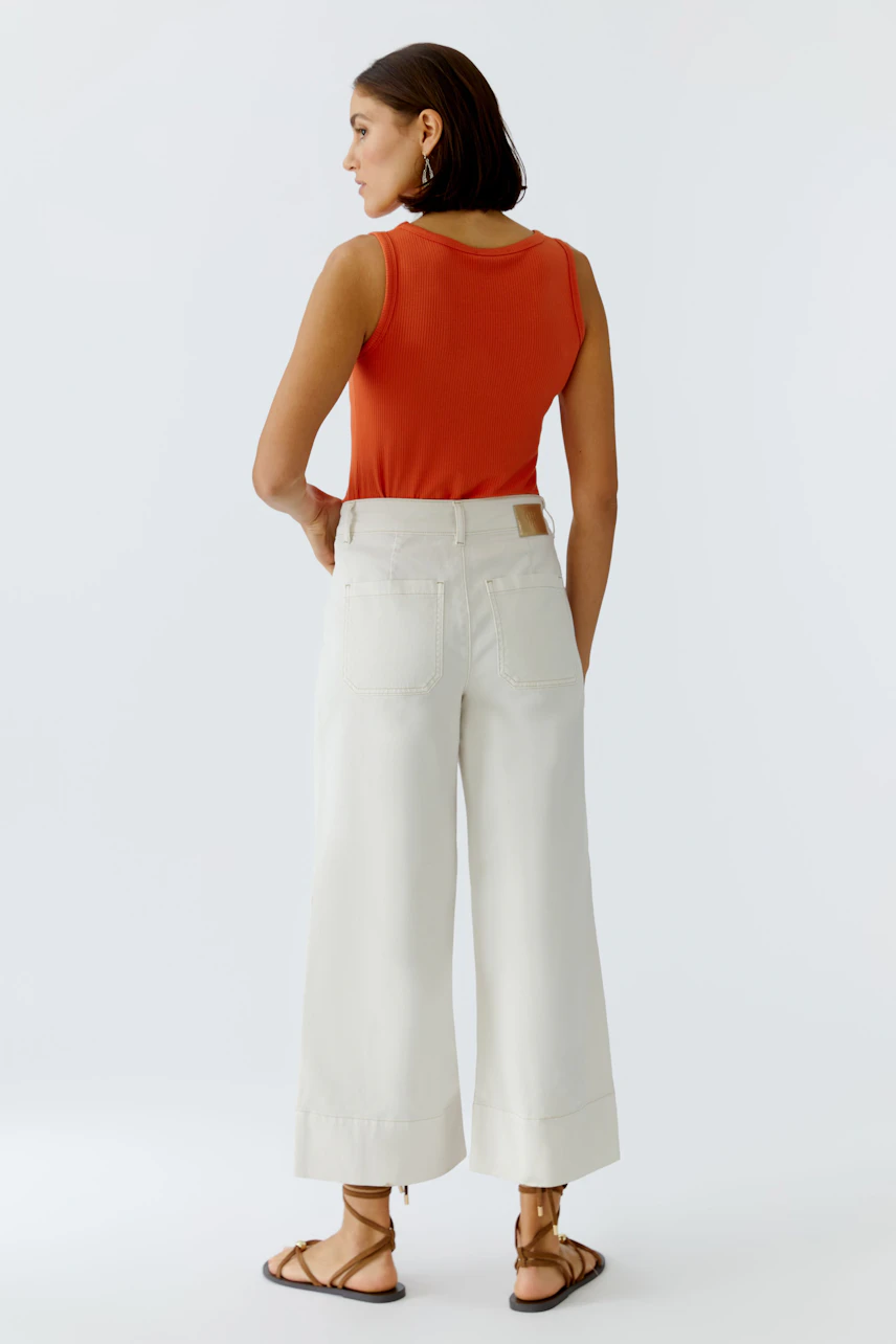 Wide leg jeans: Woman wearing white wide leg jeans with a casual fit, showcasing a relaxed style.