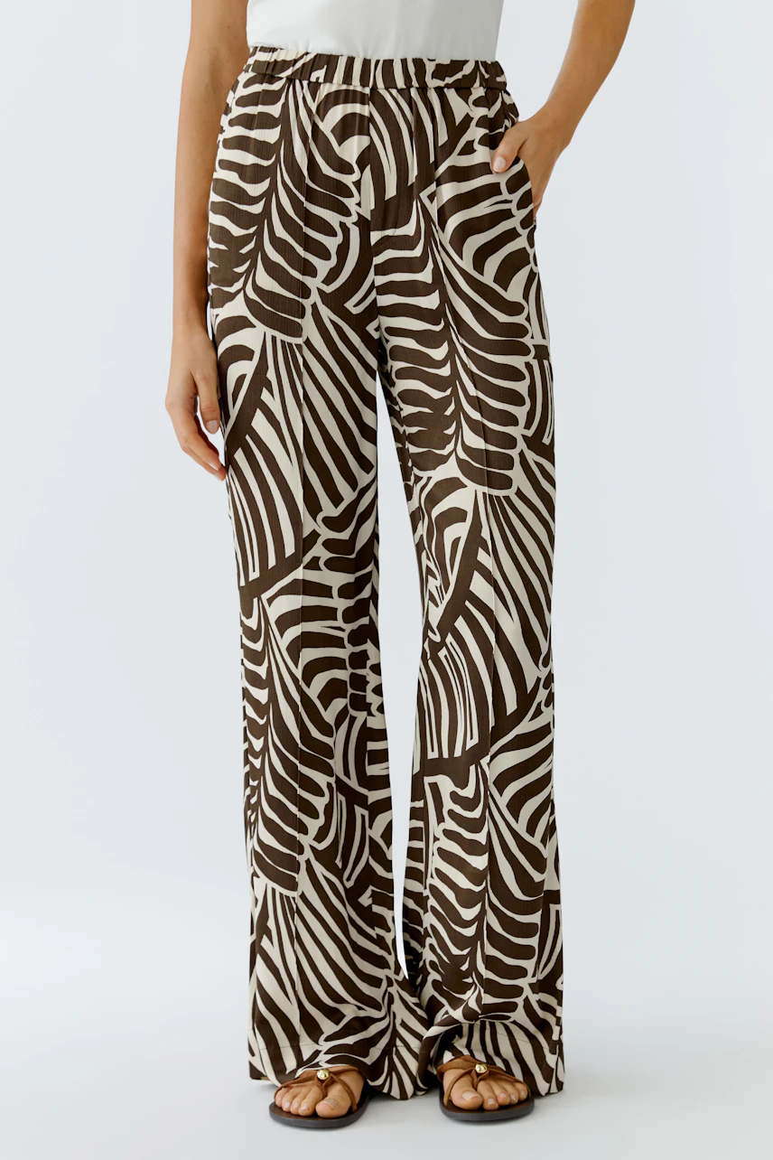 Stylish women's pants with a bold leaf pattern, featuring an elastic waistband for comfort.