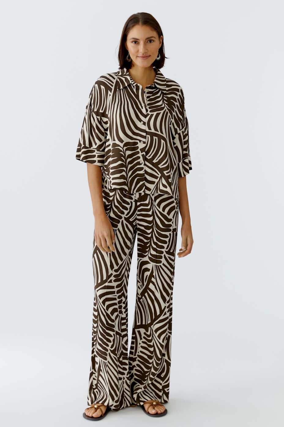 Trendy women's pants with a bold leaf pattern, featuring a comfortable elastic waistband.