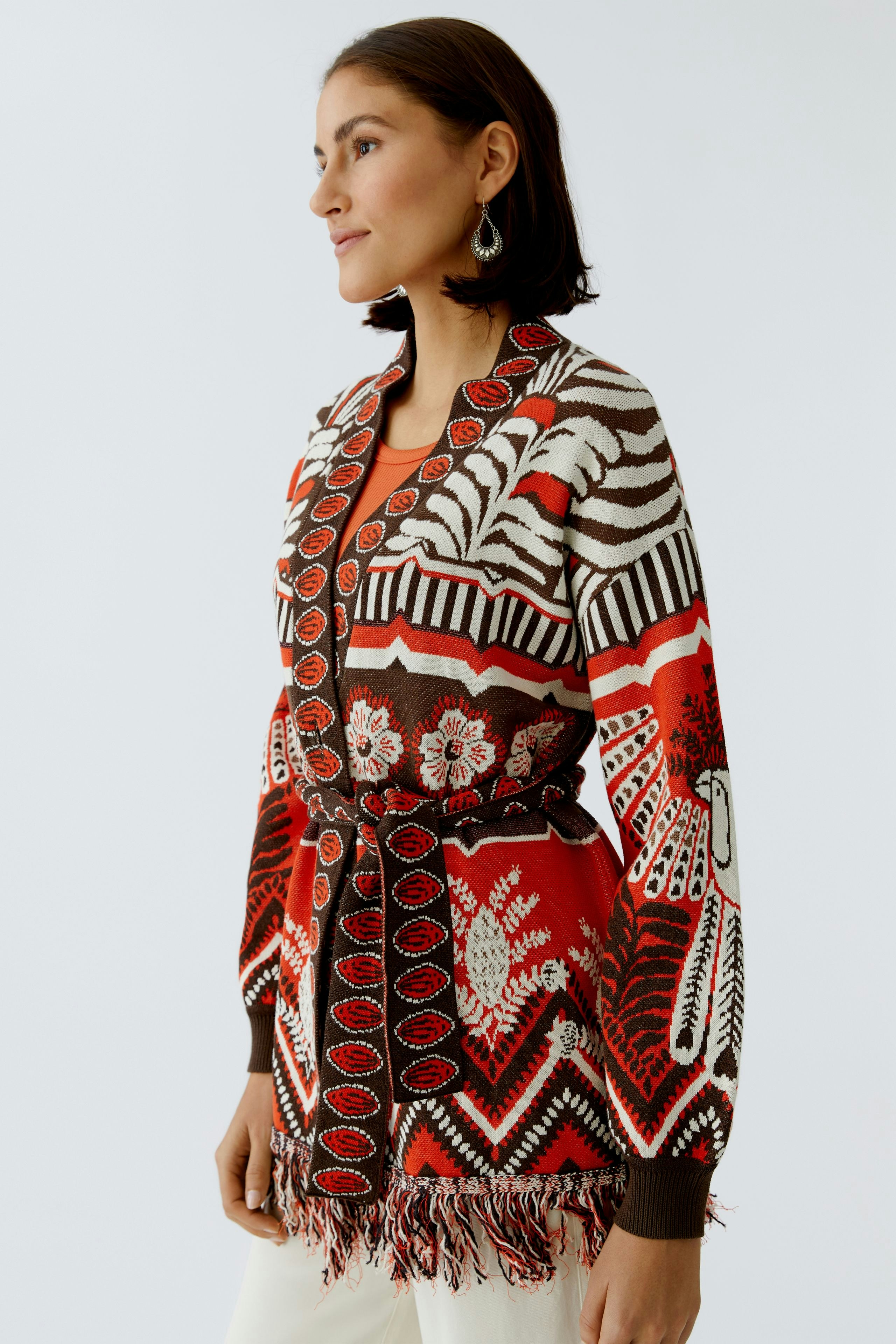 Bunte Damen-Strickjacke mit fransigen Details, lässig getragen von einer Frau.