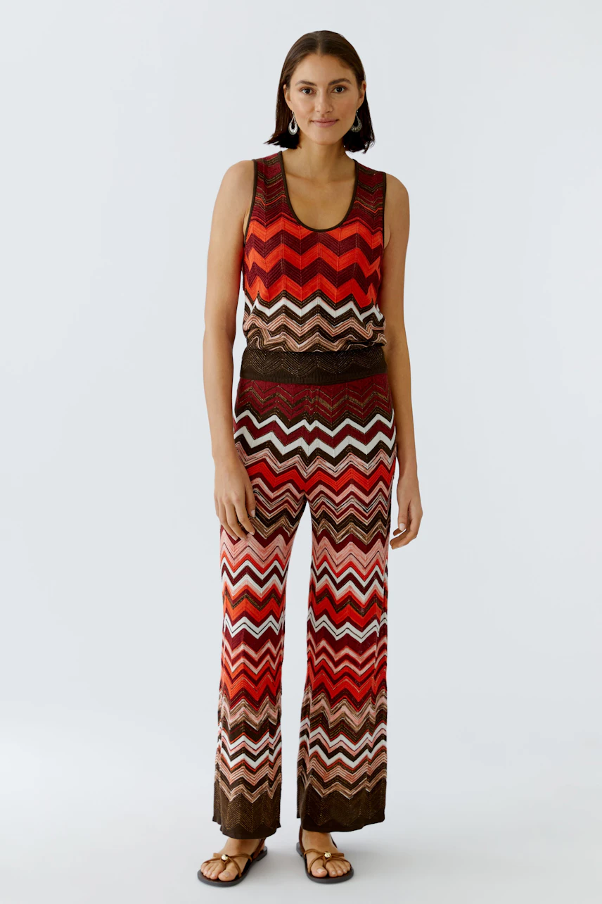 Casual women's knit pants: A woman in colorful zigzag knit pants and matching top stands confidently.