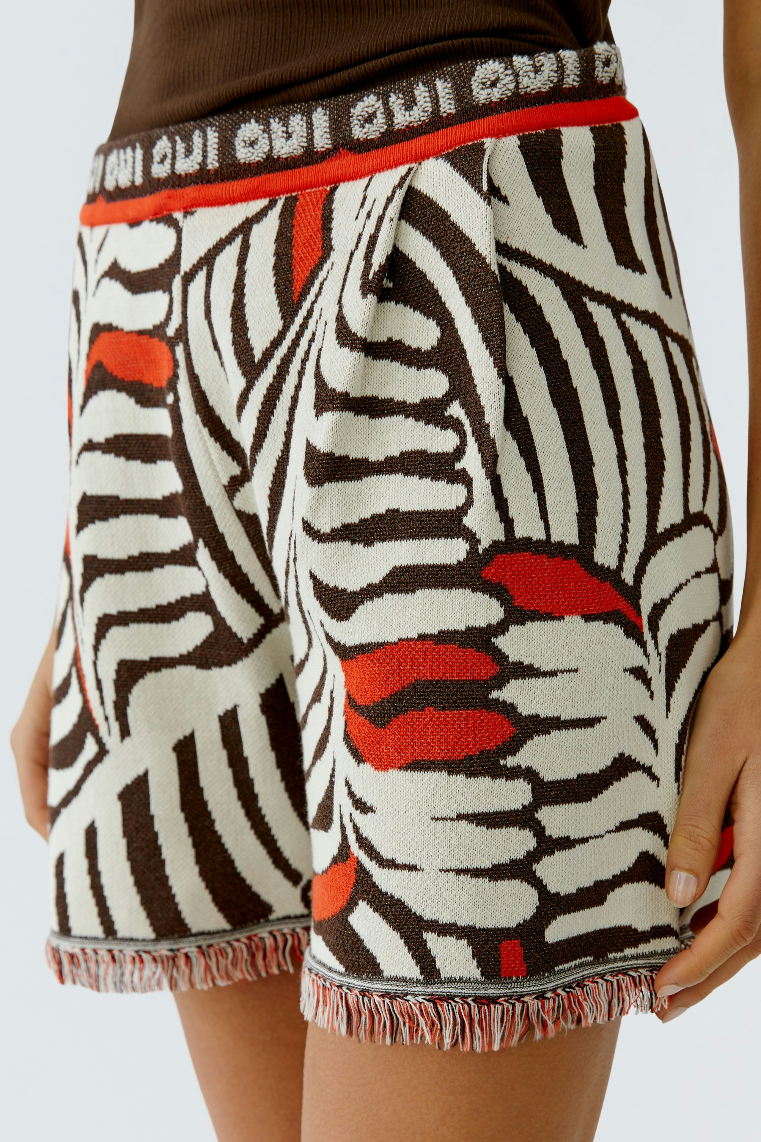 Bequeme Damen-Shorts mit buntem Muster und fransigem Saum, ideal für lässige Sommerlooks.