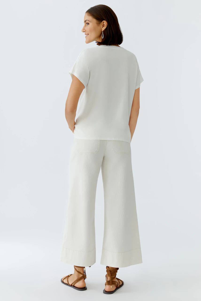 Bequeme Damen-T-Shirt: Frau in einem hellen T-Shirt mit kurzen Ärmeln und lässiger Passform von hinten.