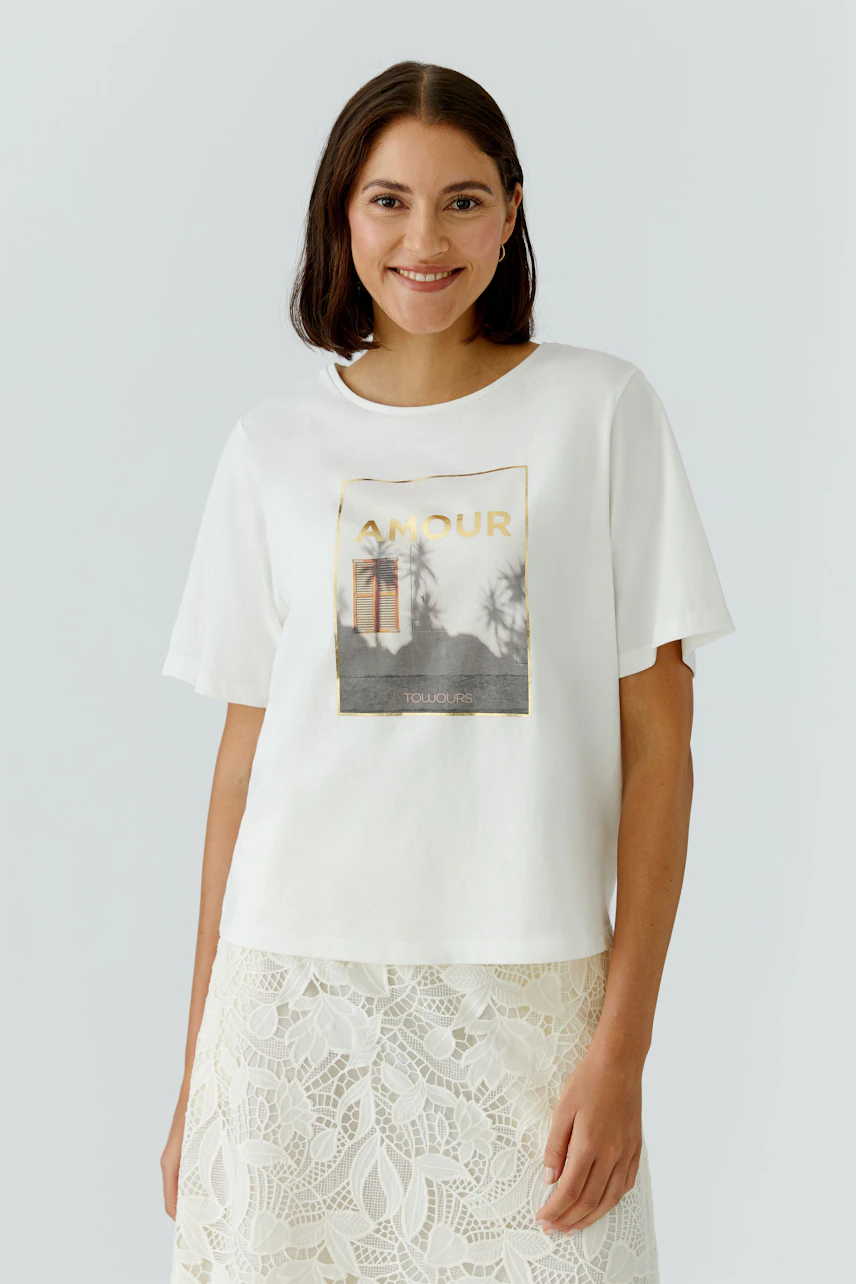 Casual women's T-shirt: A woman in a white tee with a graphic print, paired with a light skirt.