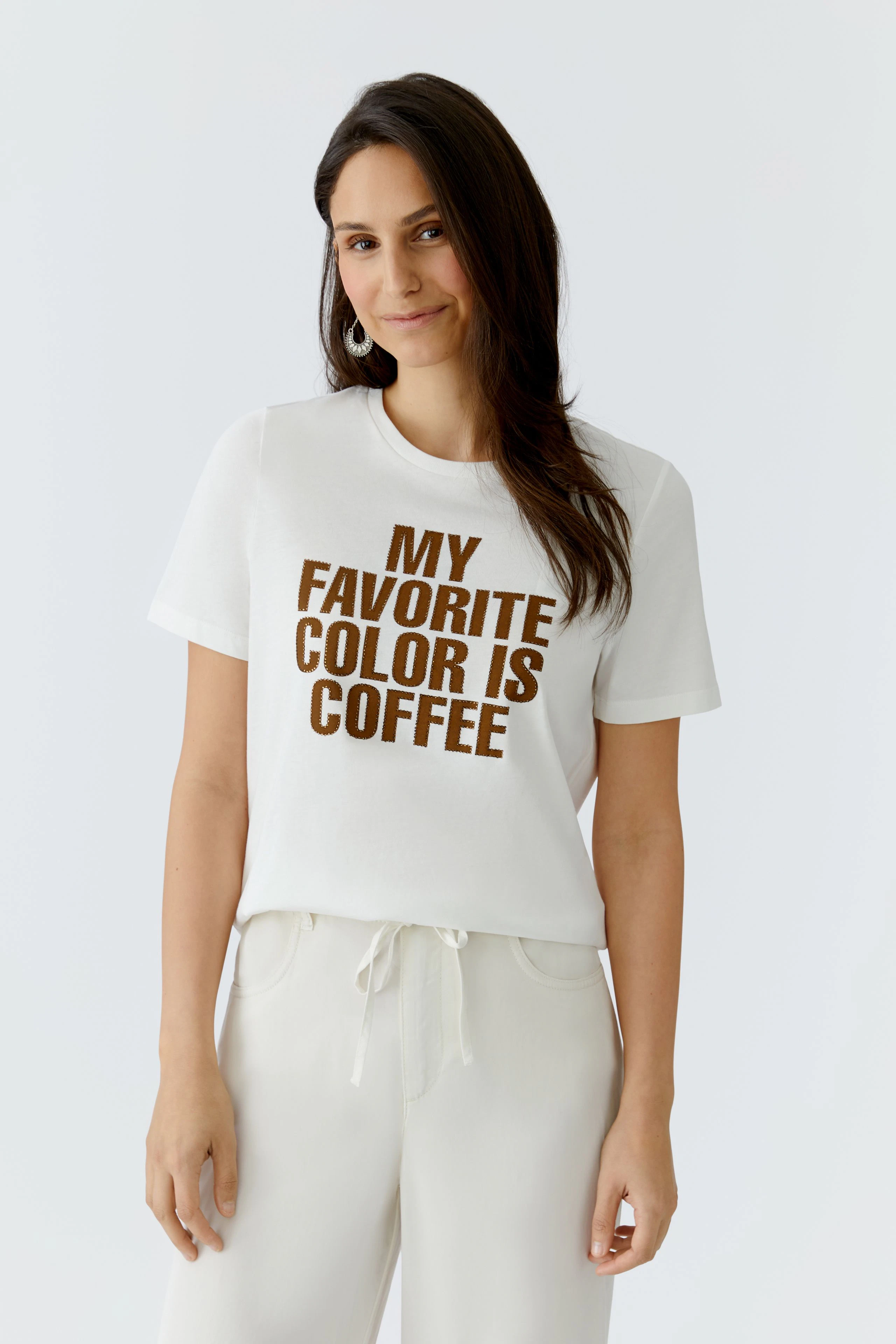 Damen-T-Shirt: Frau trägt ein weißes T-Shirt mit braunem Schriftzug "MY FAVORITE COLOR IS COFFEE".