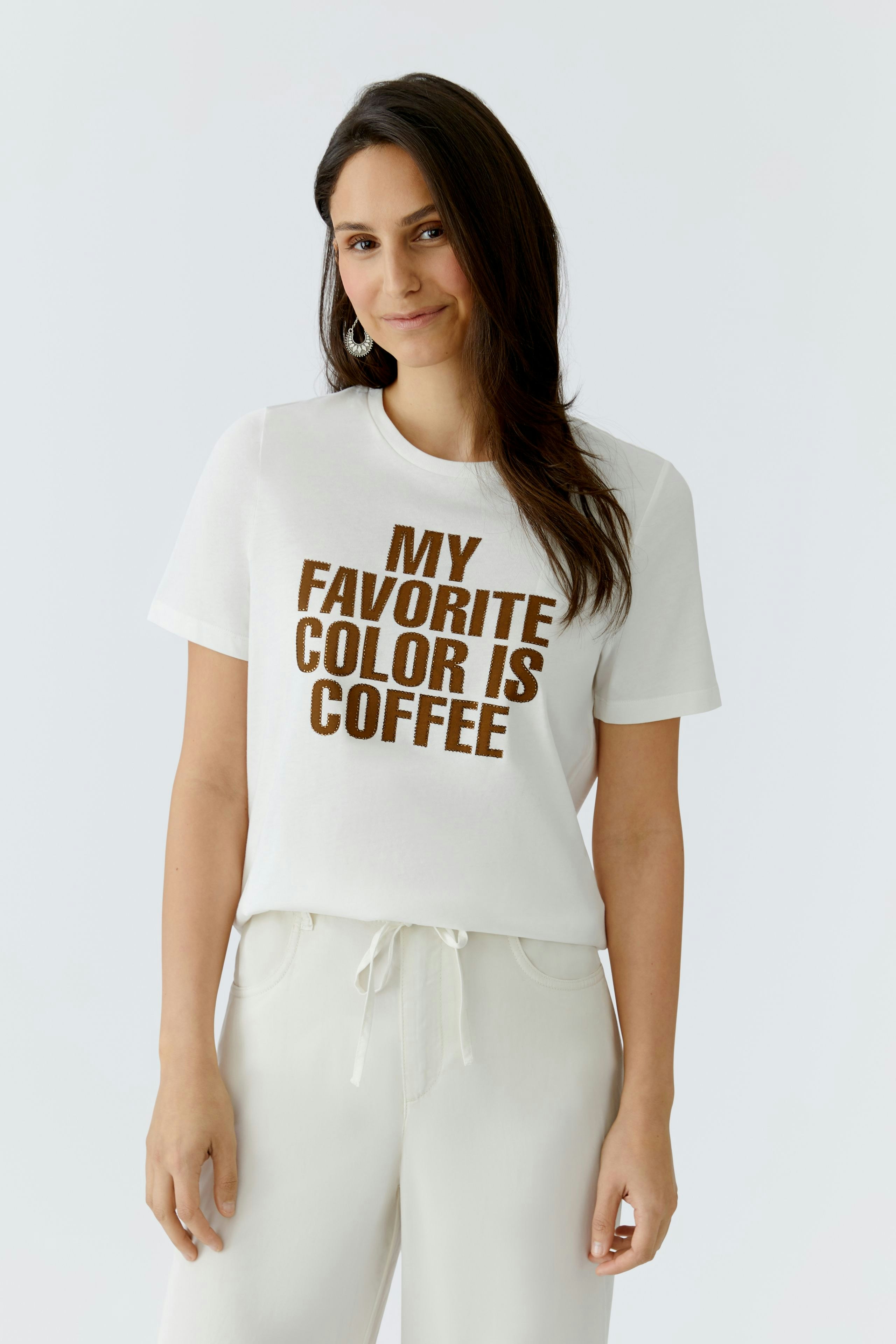 Damen-T-Shirt: Frau trägt ein weißes T-Shirt mit braunem Schriftzug "MY FAVORITE COLOR IS COFFEE".