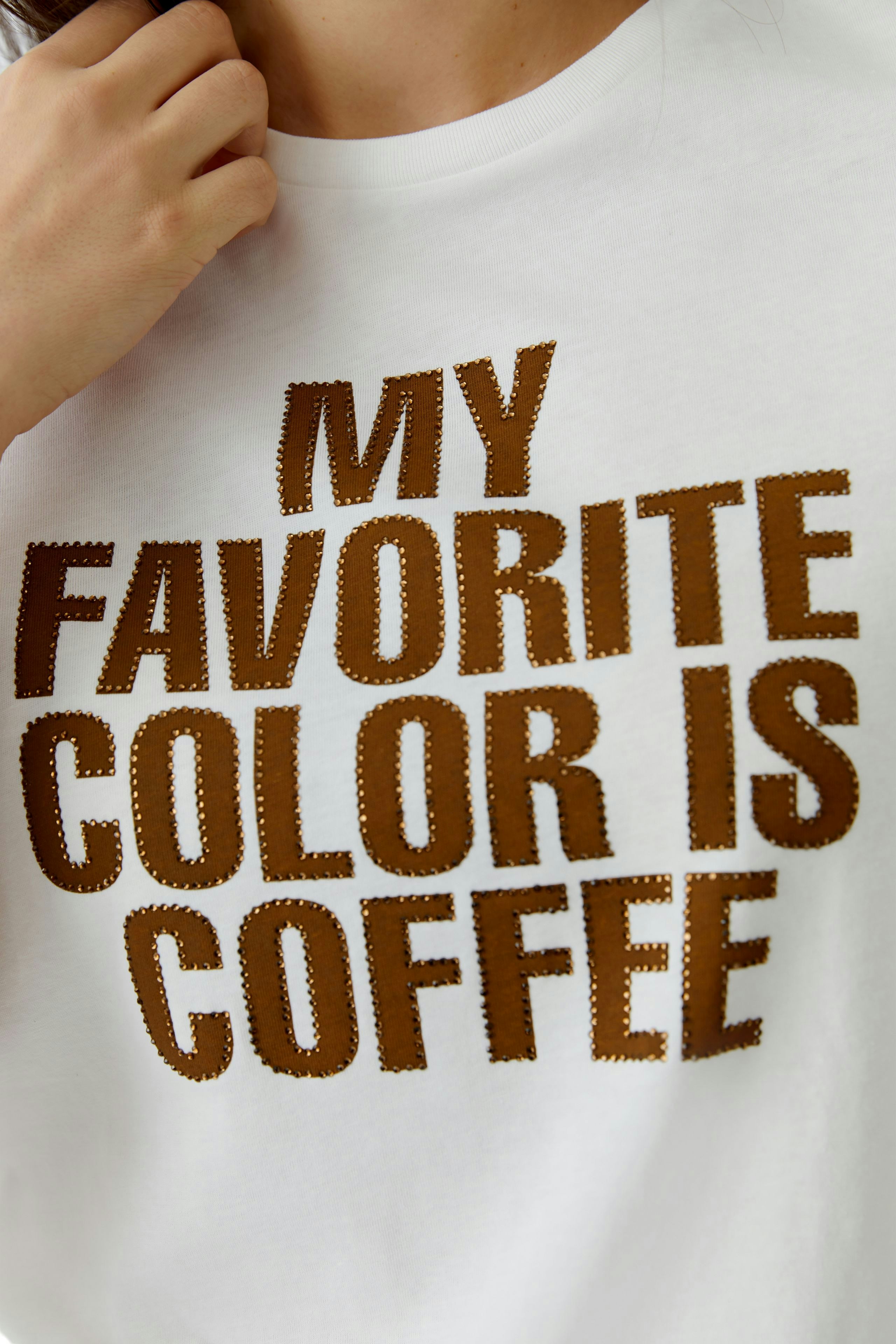 Damen-T-Shirt: Frau trägt ein weißes Shirt mit braunem Schriftzug "MY FAVORITE COLOR IS COFFEE".