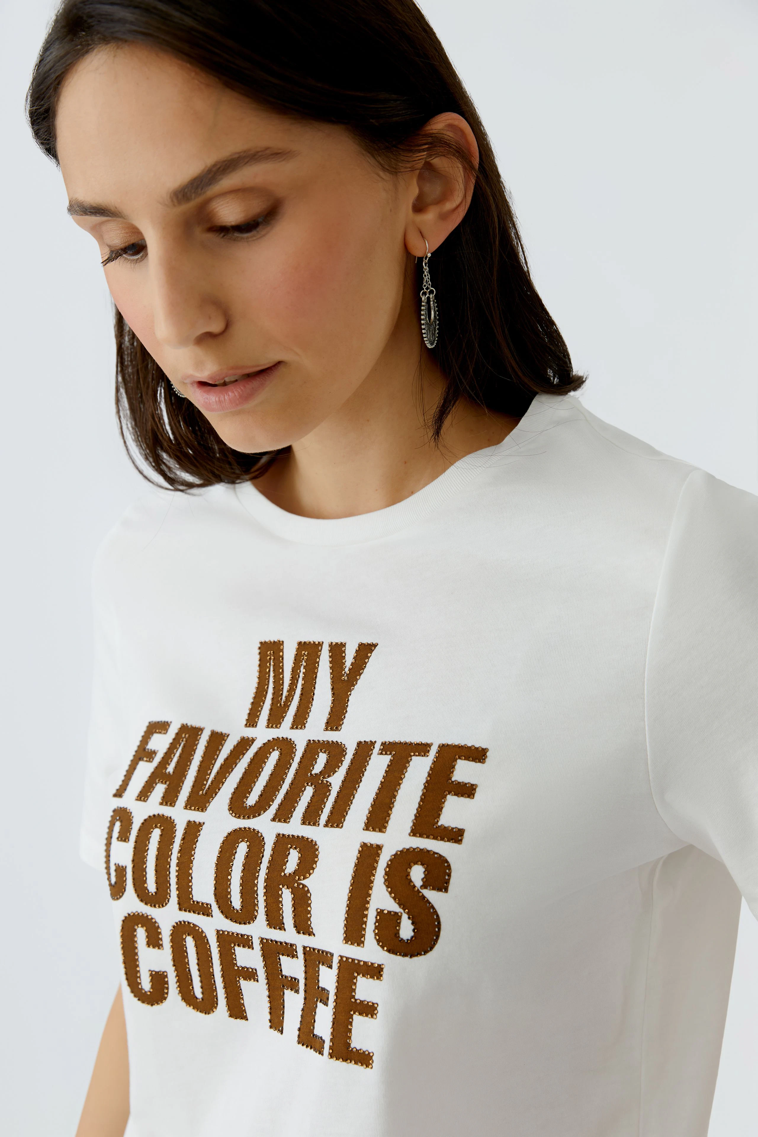 Damen-T-Shirt: Frau trägt ein weißes Shirt mit dem Aufdruck 'MY FAVORITE COLOR IS COFFEE'.