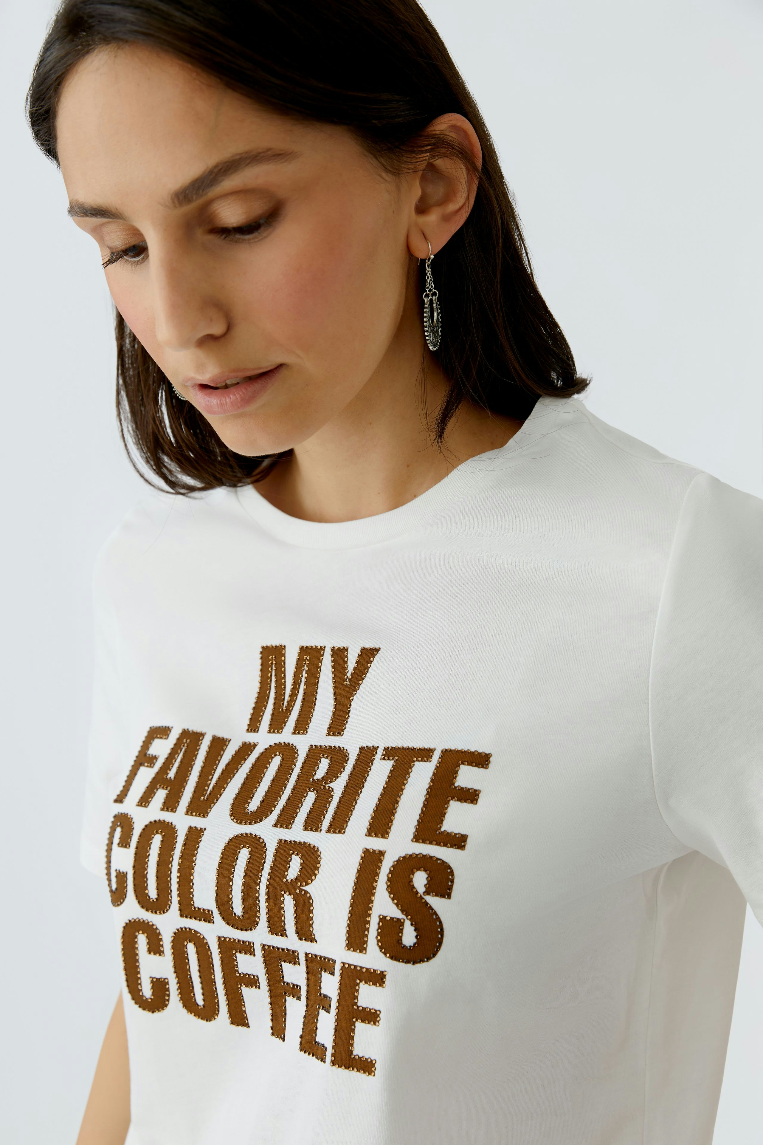 Damen-T-Shirt: Frau trägt ein weißes Shirt mit dem Aufdruck 'MY FAVORITE COLOR IS COFFEE'.