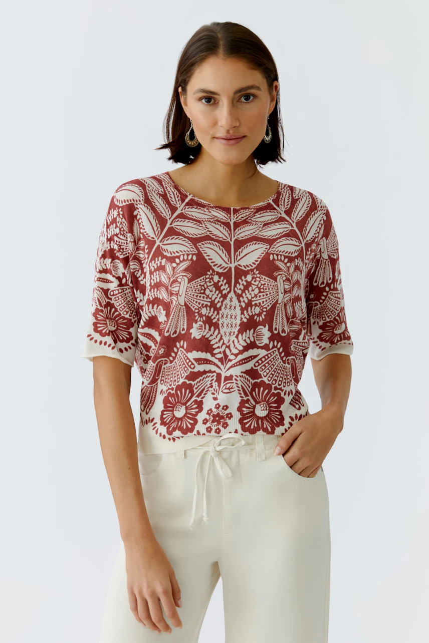 Casual women's pullover: Young woman in a red floral pullover with short sleeves and relaxed fit.