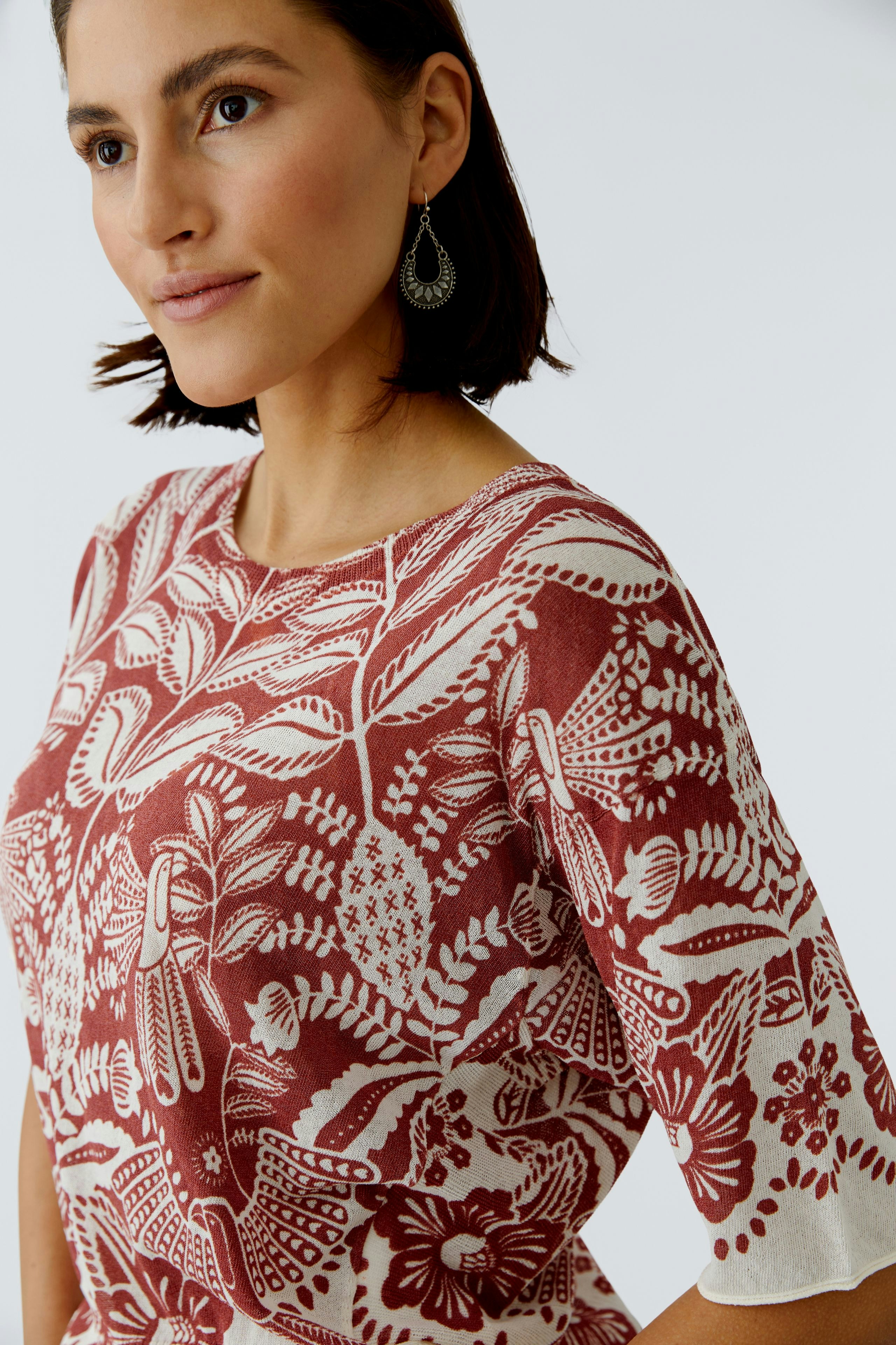 Damen-Pullover mit floralem Muster, lässig geschnitten, getragen von einer Frau.