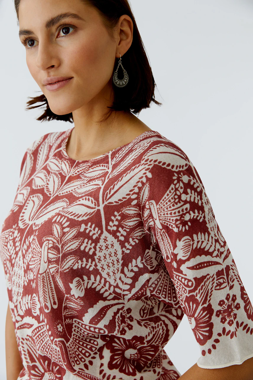 Casual women's pullover: A woman in a patterned pullover with short sleeves, showcasing a vibrant design.