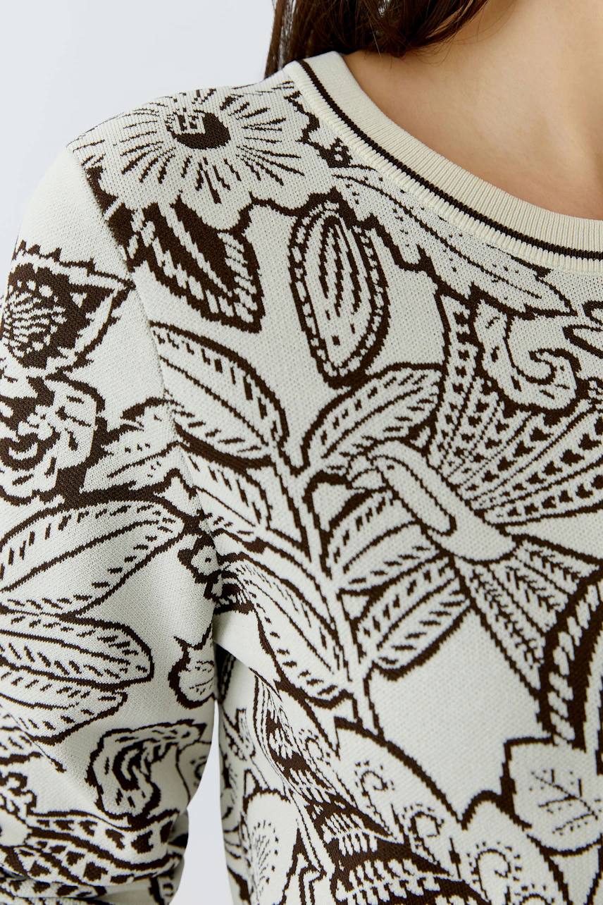 Casual women's pullover: Close-up of a woman in a floral-patterned pullover with a round neckline.