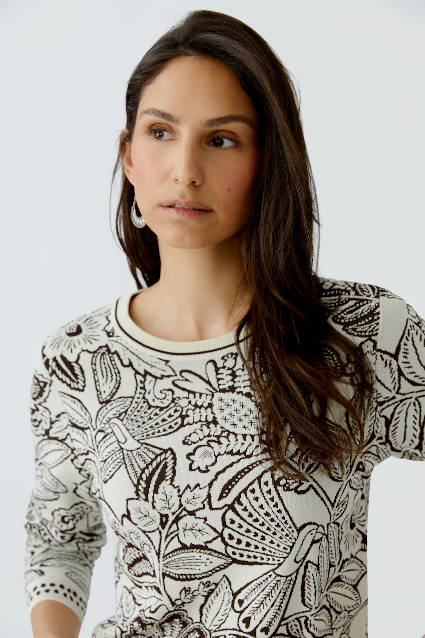 Modern women's pullover: A woman in a floral-patterned pullover with three-quarter sleeves.