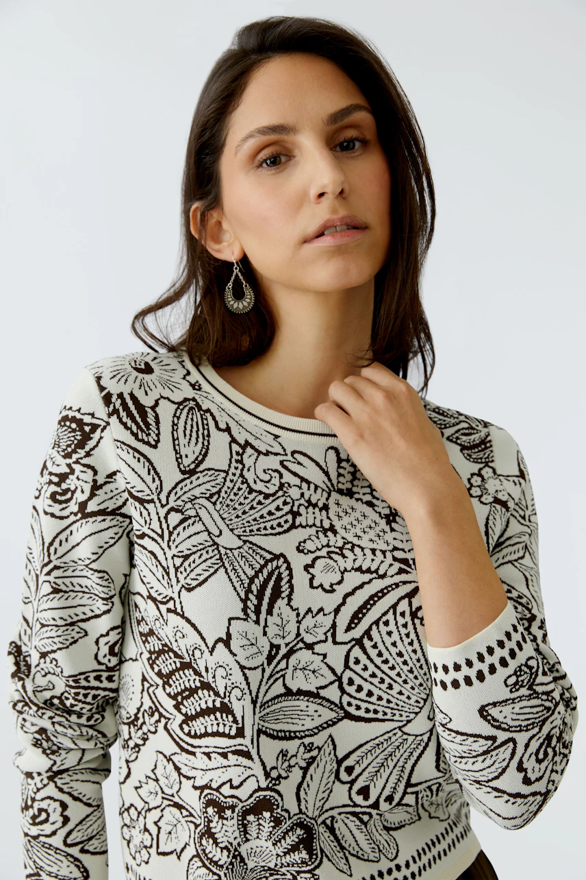 Modern women's pullover: A woman in a floral-patterned pullover, looking confidently at the camera.