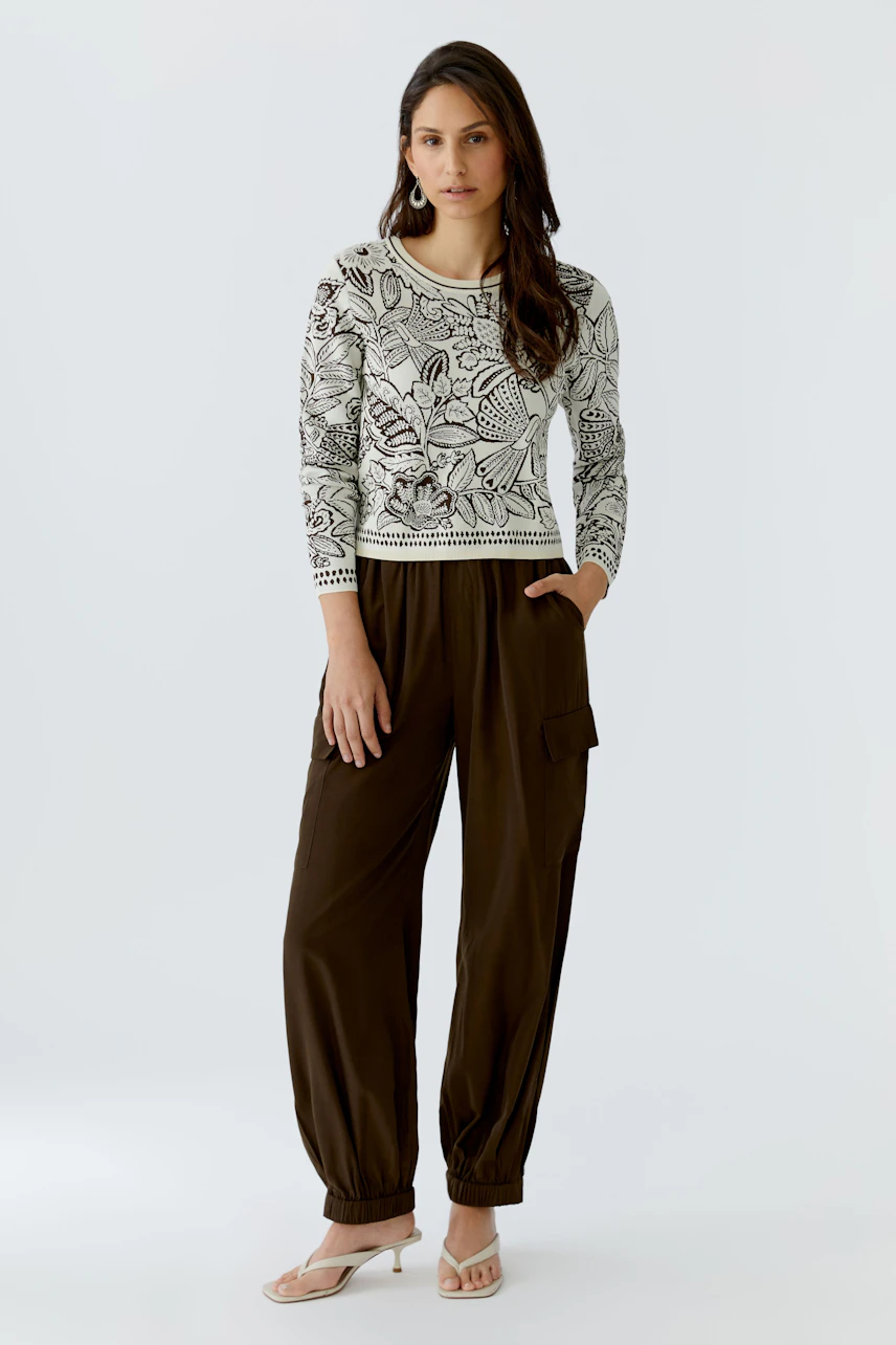 Casual women's pullover: A woman in a floral-patterned pullover paired with relaxed-fit pants.
