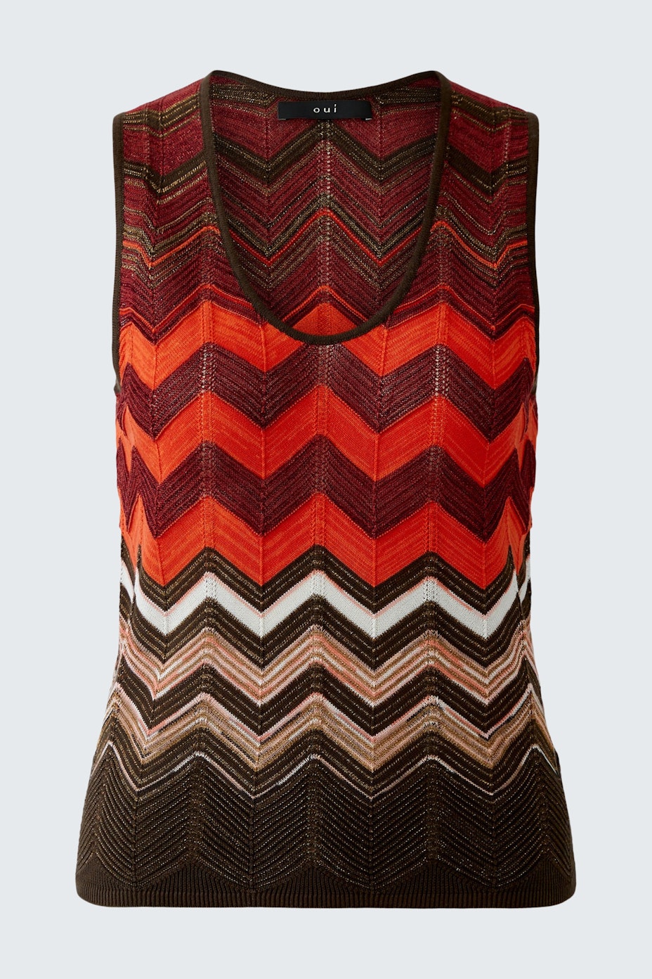 Stylish women's top: A woman in a vibrant, zigzag-patterned sleeveless top in warm colors.