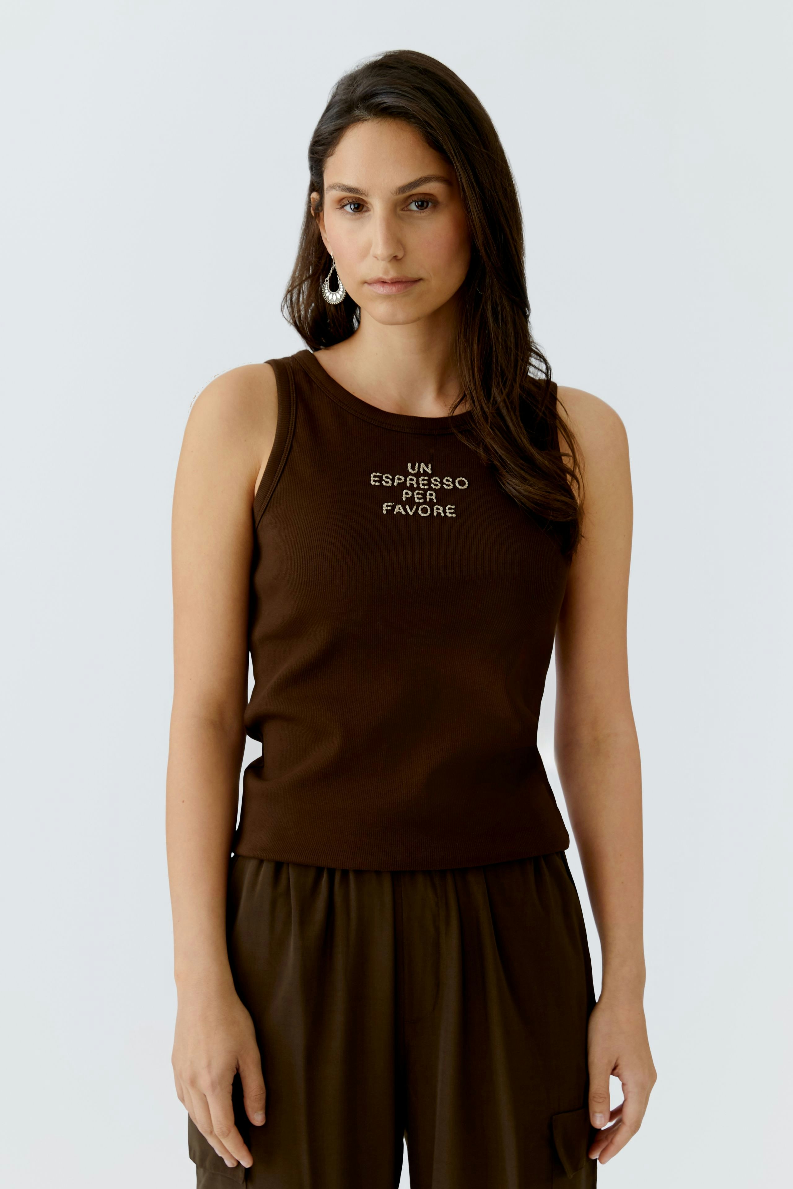 Braunes Damen-Tank Top: Frau trägt ein ärmelloses Top mit Schriftzug und kombiniert es lässig.