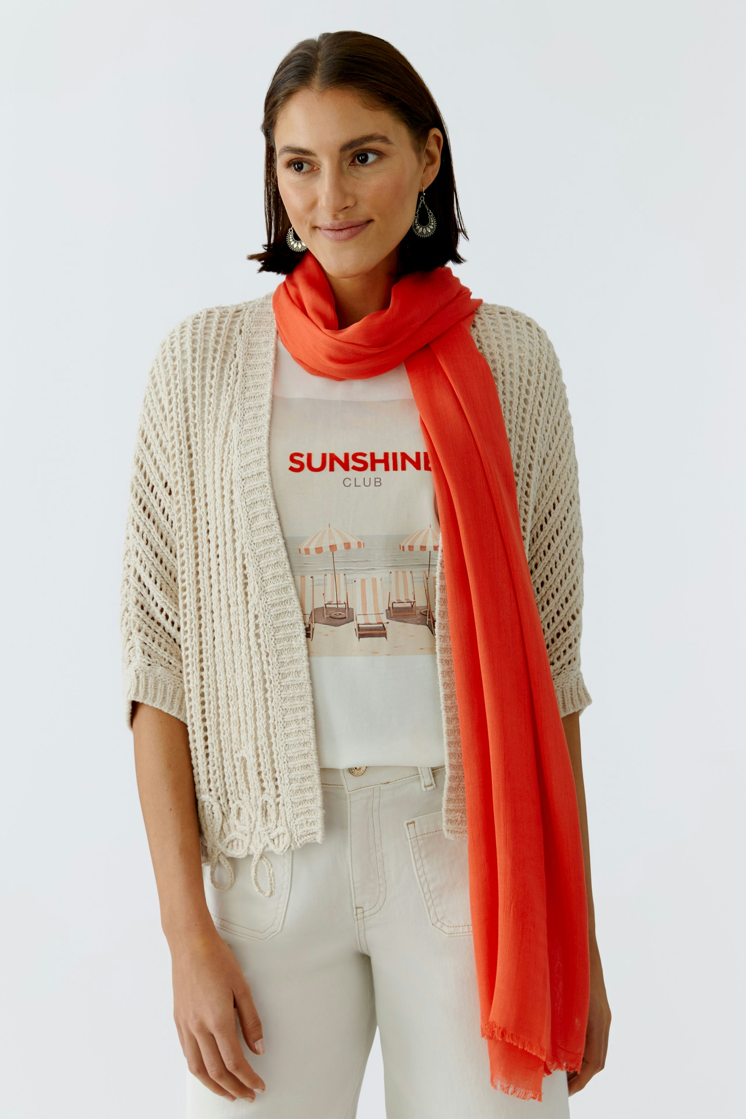 Leichter Damen-Schal in leuchtendem Orange, kombiniert mit lässigem Outfit und fröhlichem Ausdruck.
