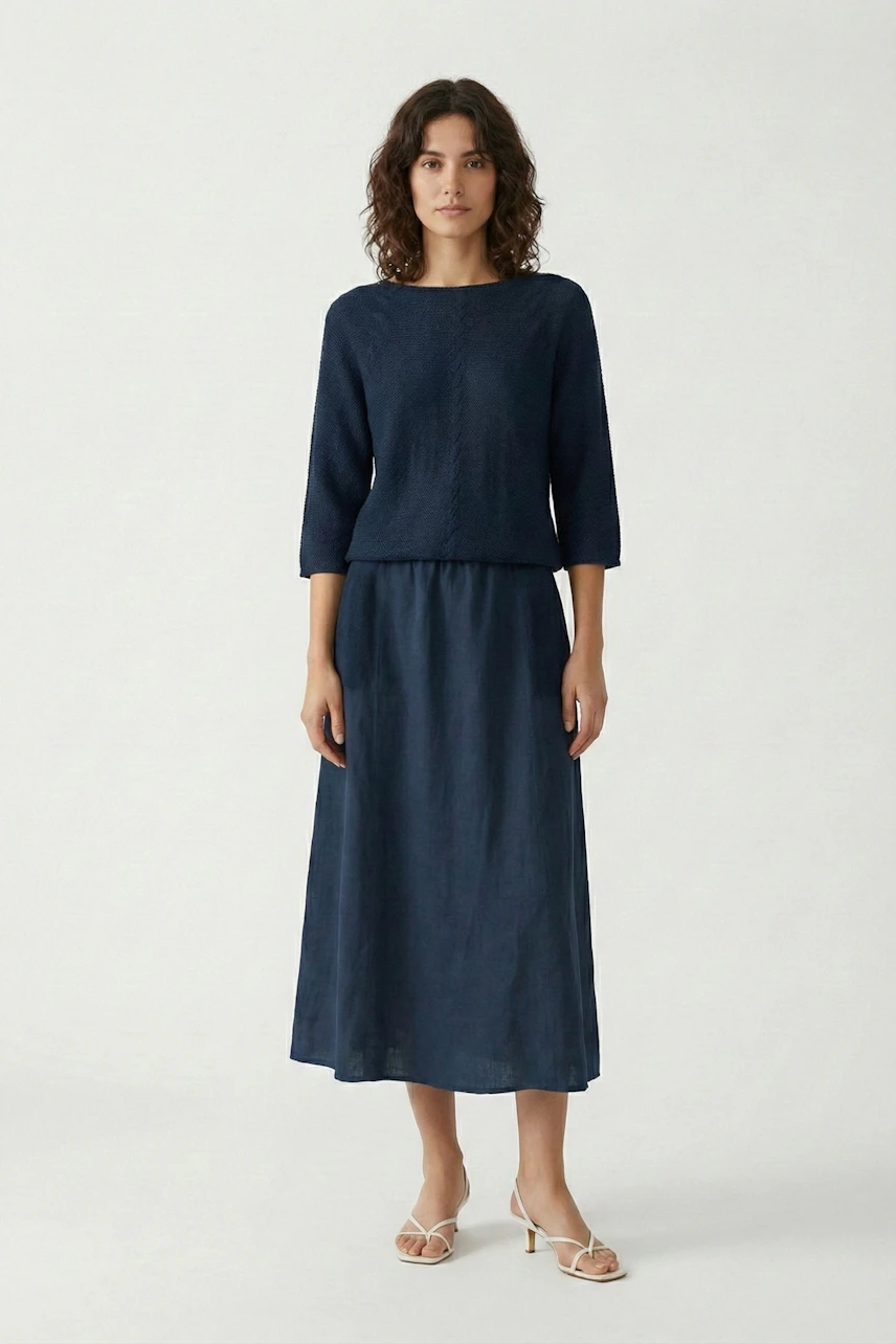 A-line skirt: Woman in a navy A-line skirt and matching top, standing confidently in sandals.