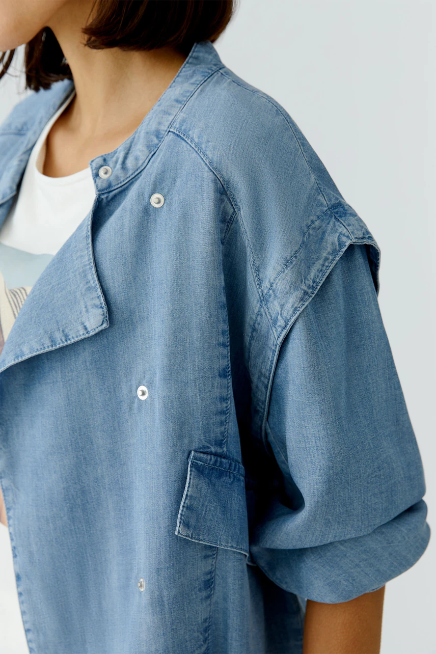 Casual women's denim jacket: A woman in a light blue jacket with a relaxed fit and stylish details.