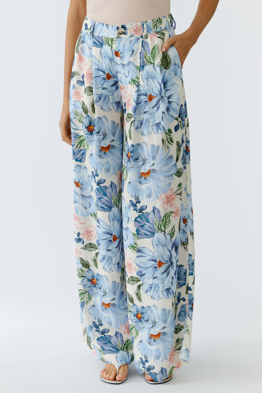 Lightweight floral Marlene trousers: Woman in wide-leg pants with blue flowers, perfect for casual wear.