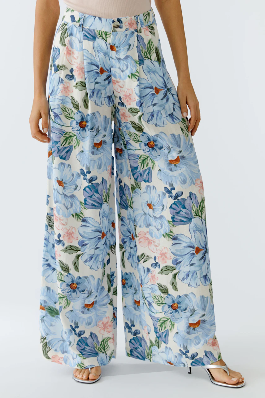 Floral wide-leg trousers: Woman in light blue floral pants with a relaxed fit, perfect for casual outings.
