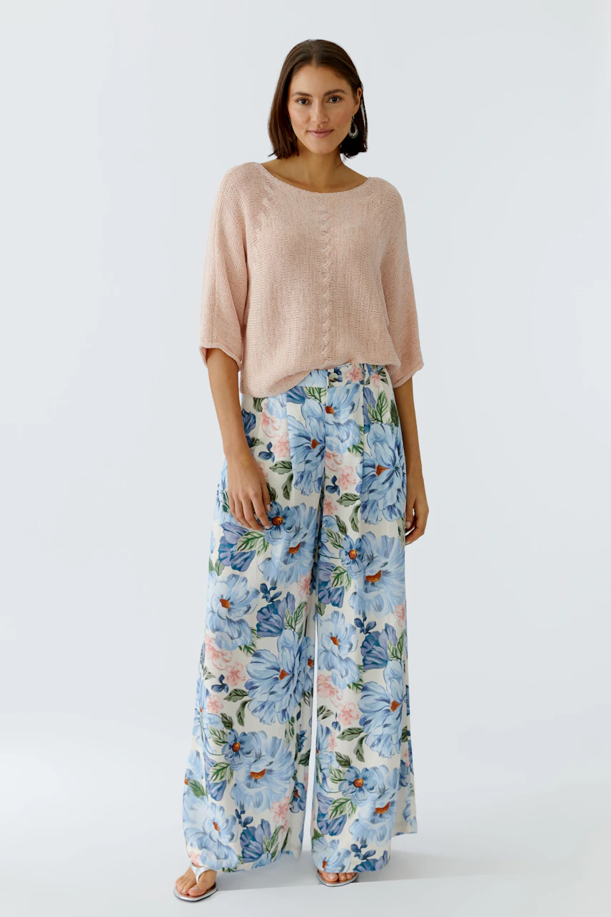 Lightweight Marlene trousers: Woman in floral wide-leg pants with a soft pink pullover.