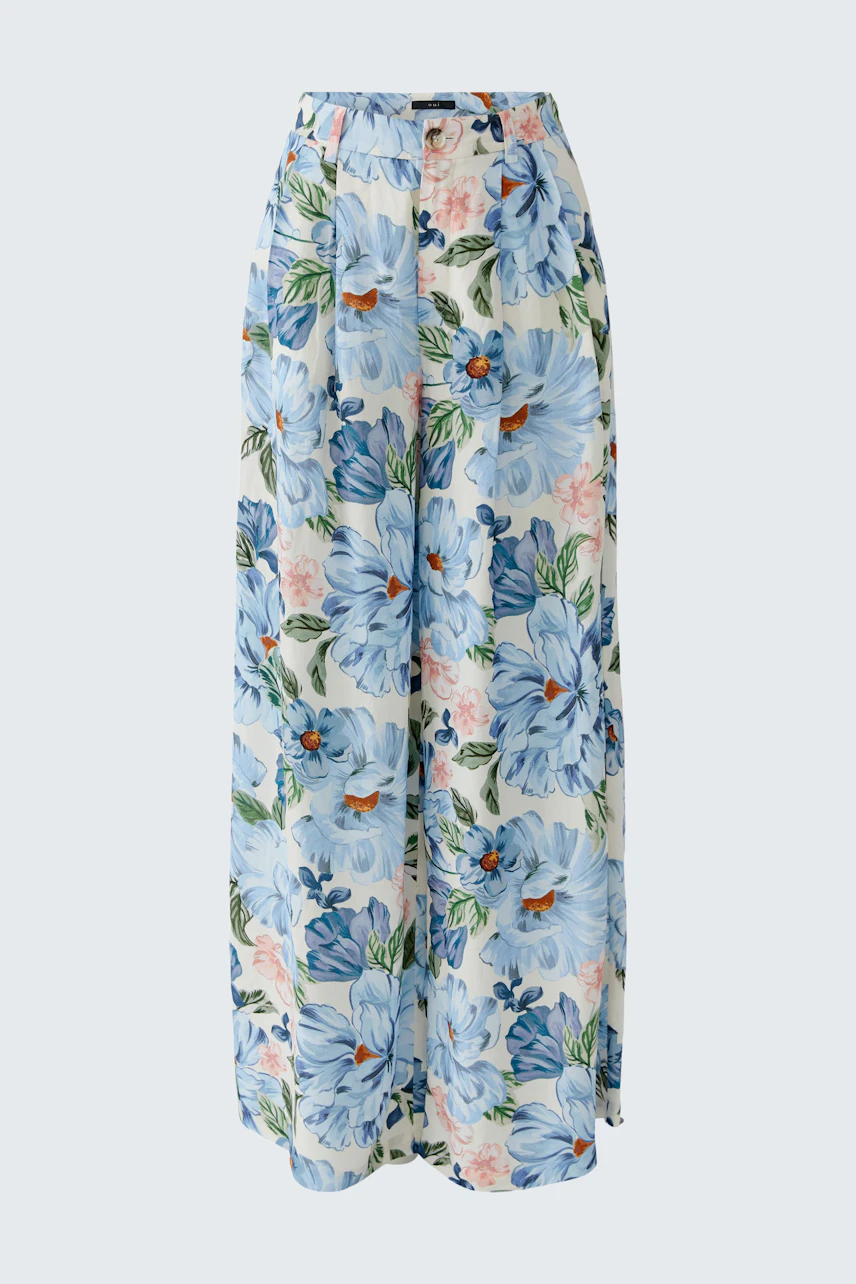 Floral Marlene trousers: A woman in wide, flowy trousers with a blue floral pattern, perfect for casual wear.