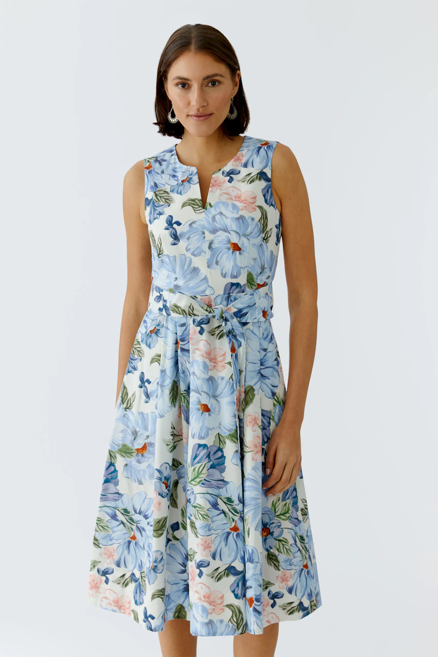 Floral midi dress: Woman in a sleeveless dress with a vibrant floral pattern, perfect for warm days.