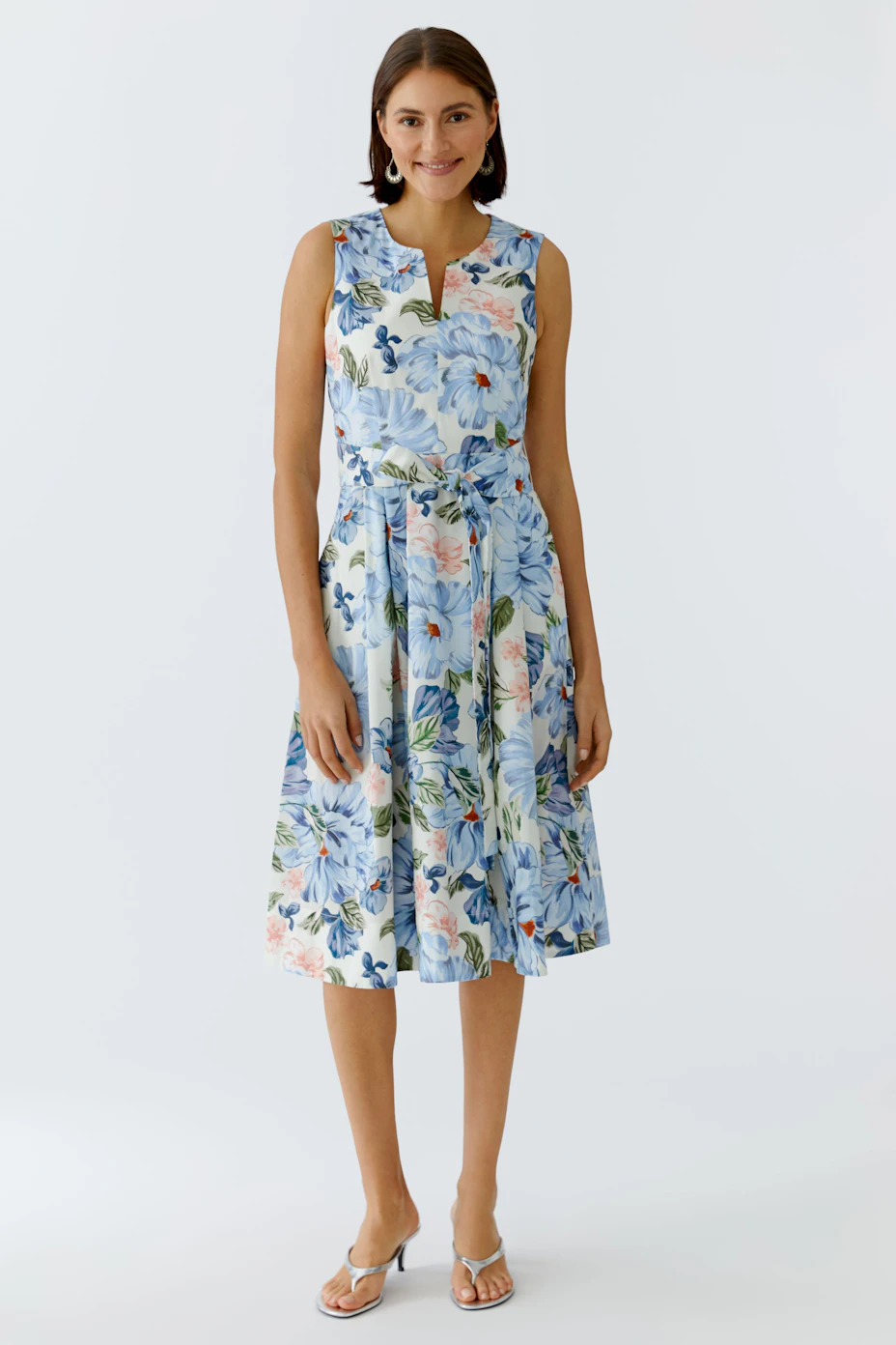 Floral midi dress: A woman in a sleeveless dress with a floral pattern and a tied waist.