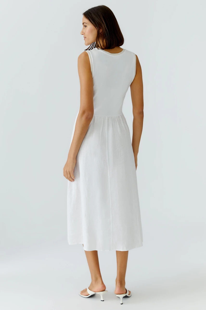 Casual midi dress: Woman in a sleeveless white midi dress with a relaxed fit, showcasing a simple design.
