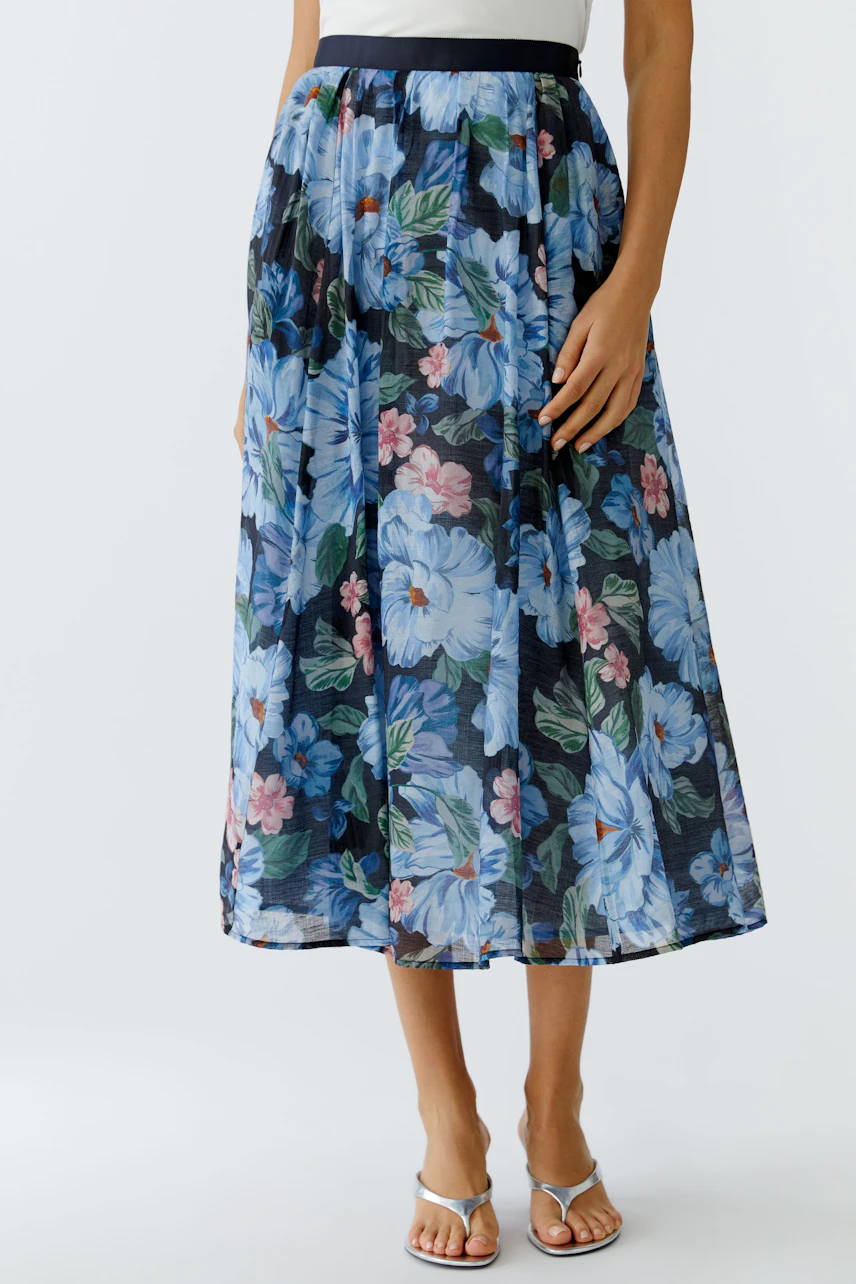 Floral pleated skirt: Woman wearing a blue floral skirt with a comfortable waistband, perfect for casual outings.