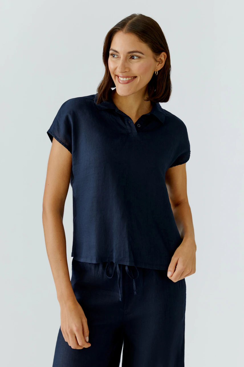 Casual women's blouse: A woman in a navy short-sleeve blouse with a collar smiles confidently.