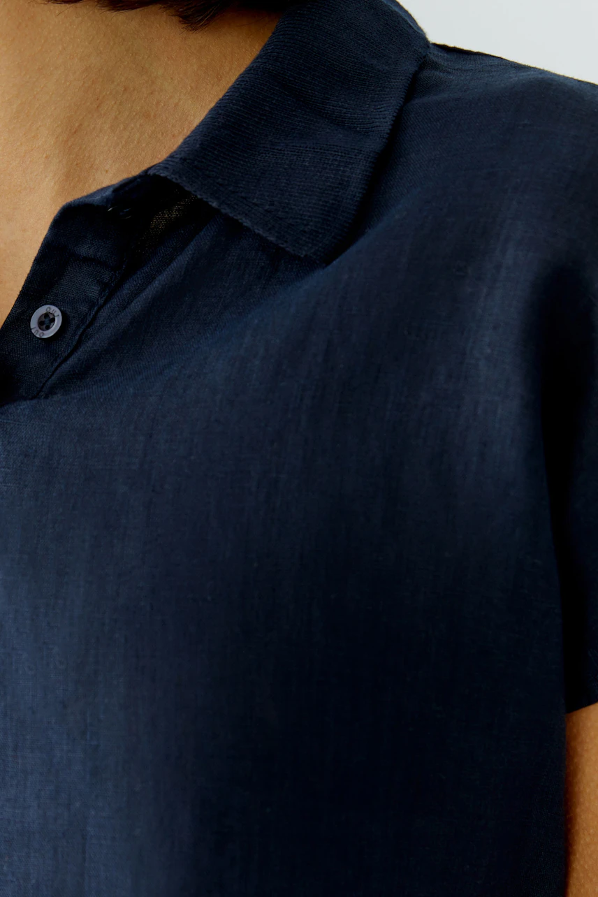 Casual women's blouse: Close-up of a woman in a dark blue short-sleeve blouse with a collar.