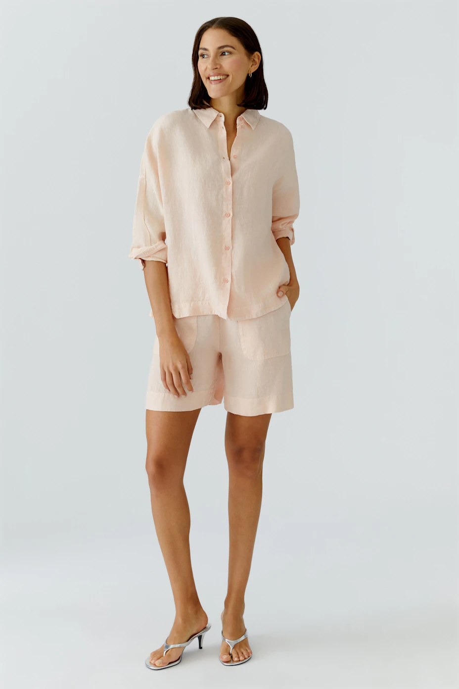 Casual women's blouse: Light pink, loose-fit blouse with button-up front and classic collar.