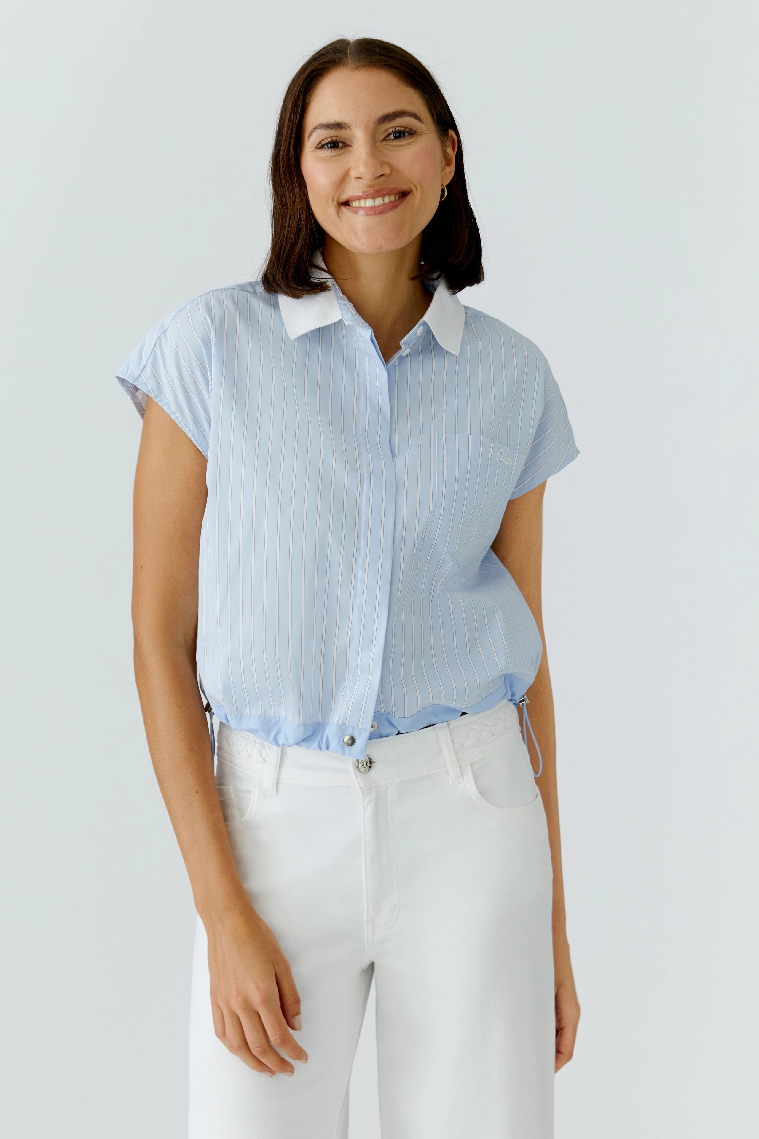 Casual women's blouse: A woman in a light blue striped blouse with a white collar and relaxed fit.
