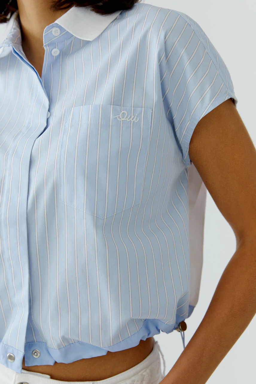 Casual women's blouse: A woman in a light blue striped blouse with a collar and short sleeves.